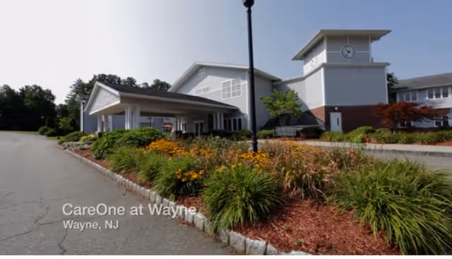CareOne at Wayne Assisted Living exterior with landscaped entrance and clock tower