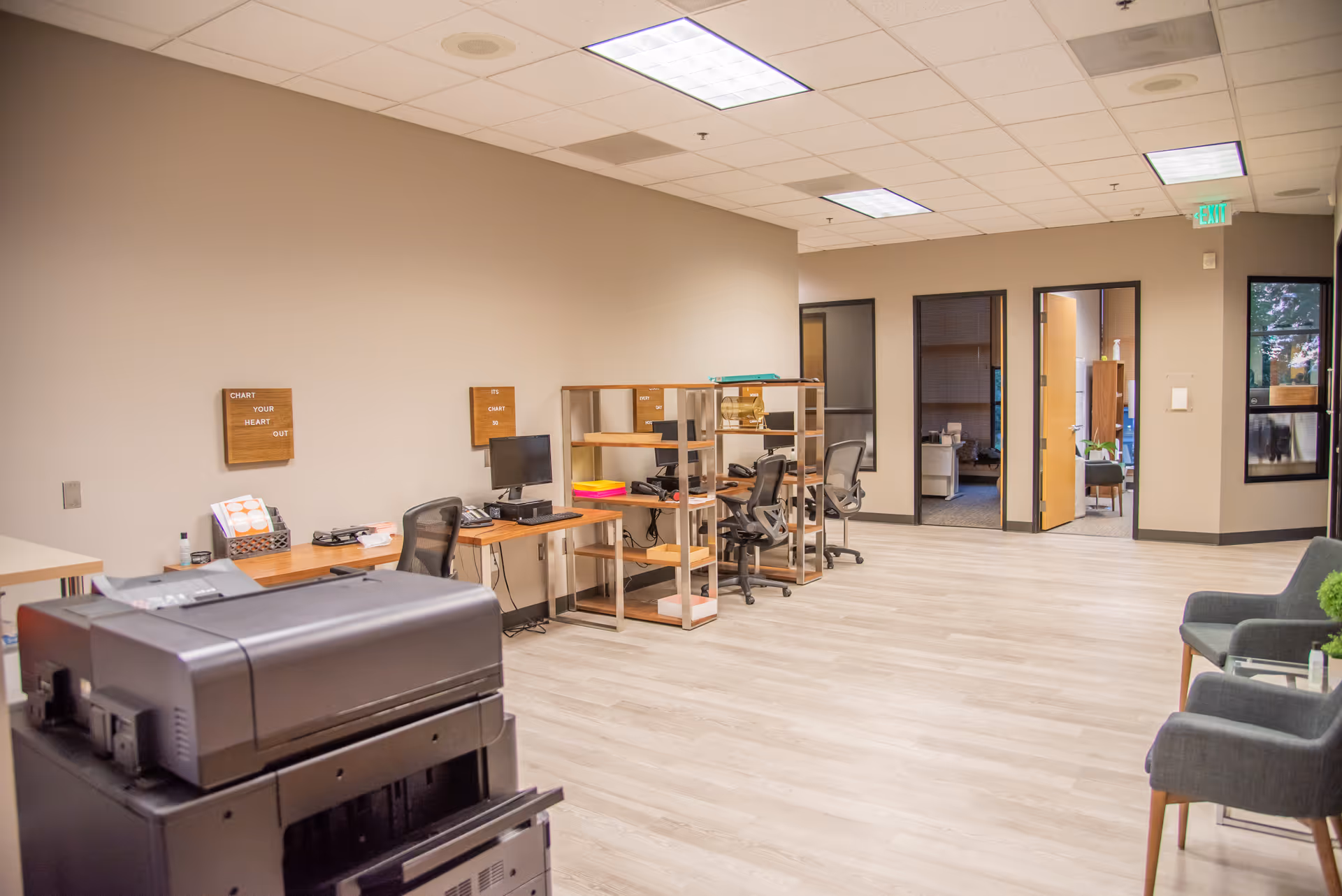 Spacious, well-lit office area with desks, computers, and shelving in a hospice facility.