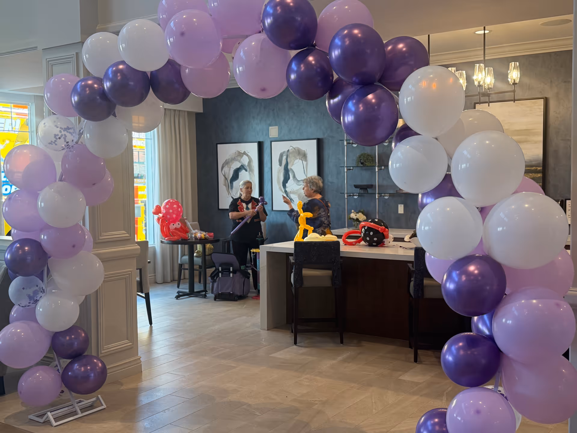 Indoor lounge at The Ivy at Blue Oaks with a purple balloon arch and two people.