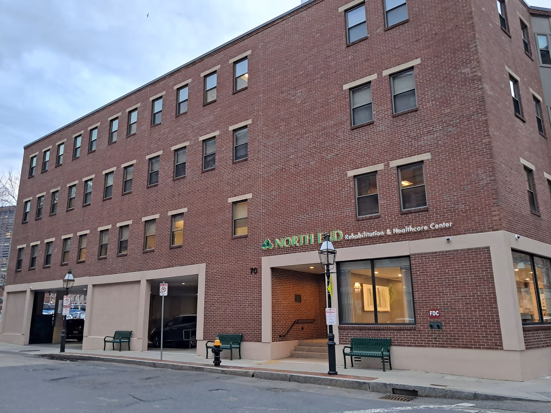 Brick multi-story building with North End Rehabilitation and Healthcare Center signage on a city street.