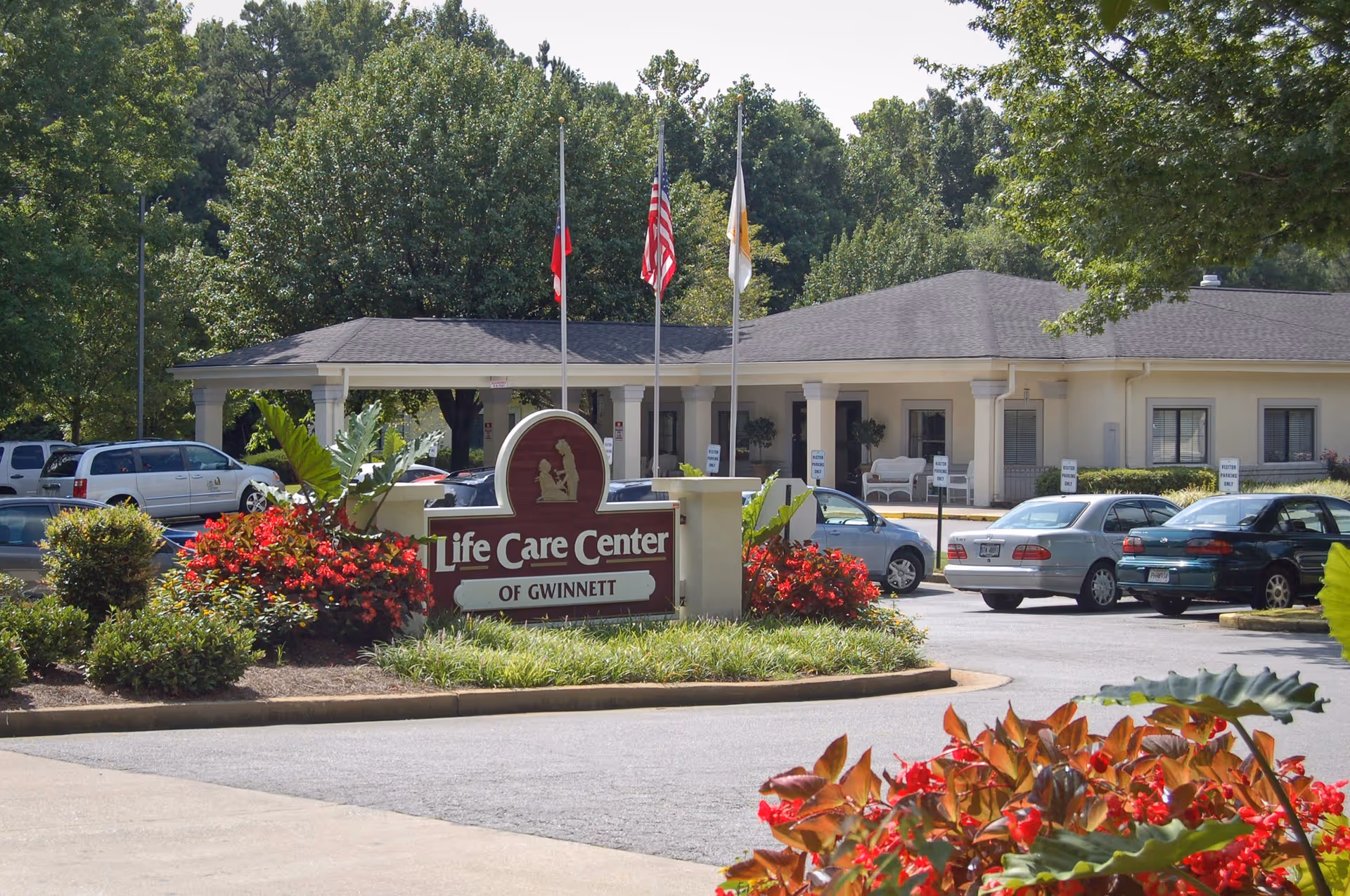 Exterior view of Life Care Center of Gwinnett with a front sign and parked cars.