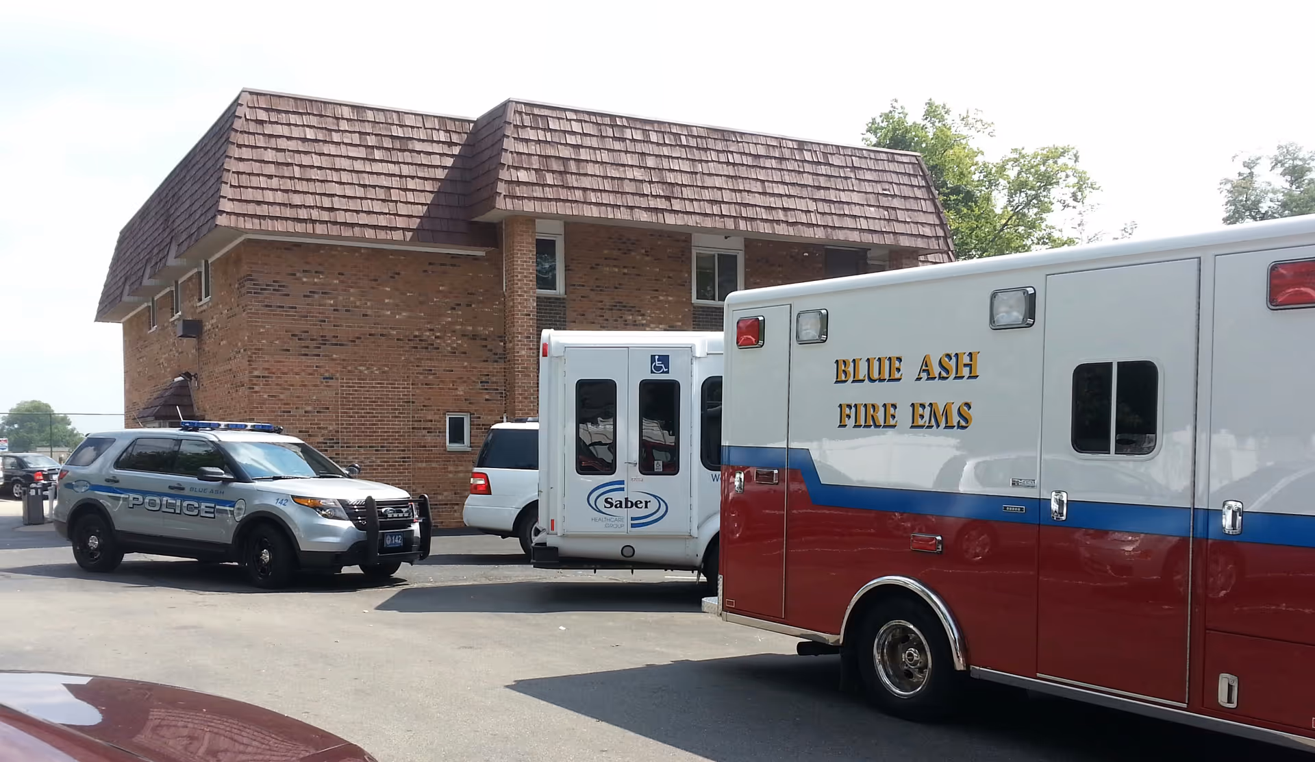 Front view of a brick care center with police and fire/EMS vehicles outside.