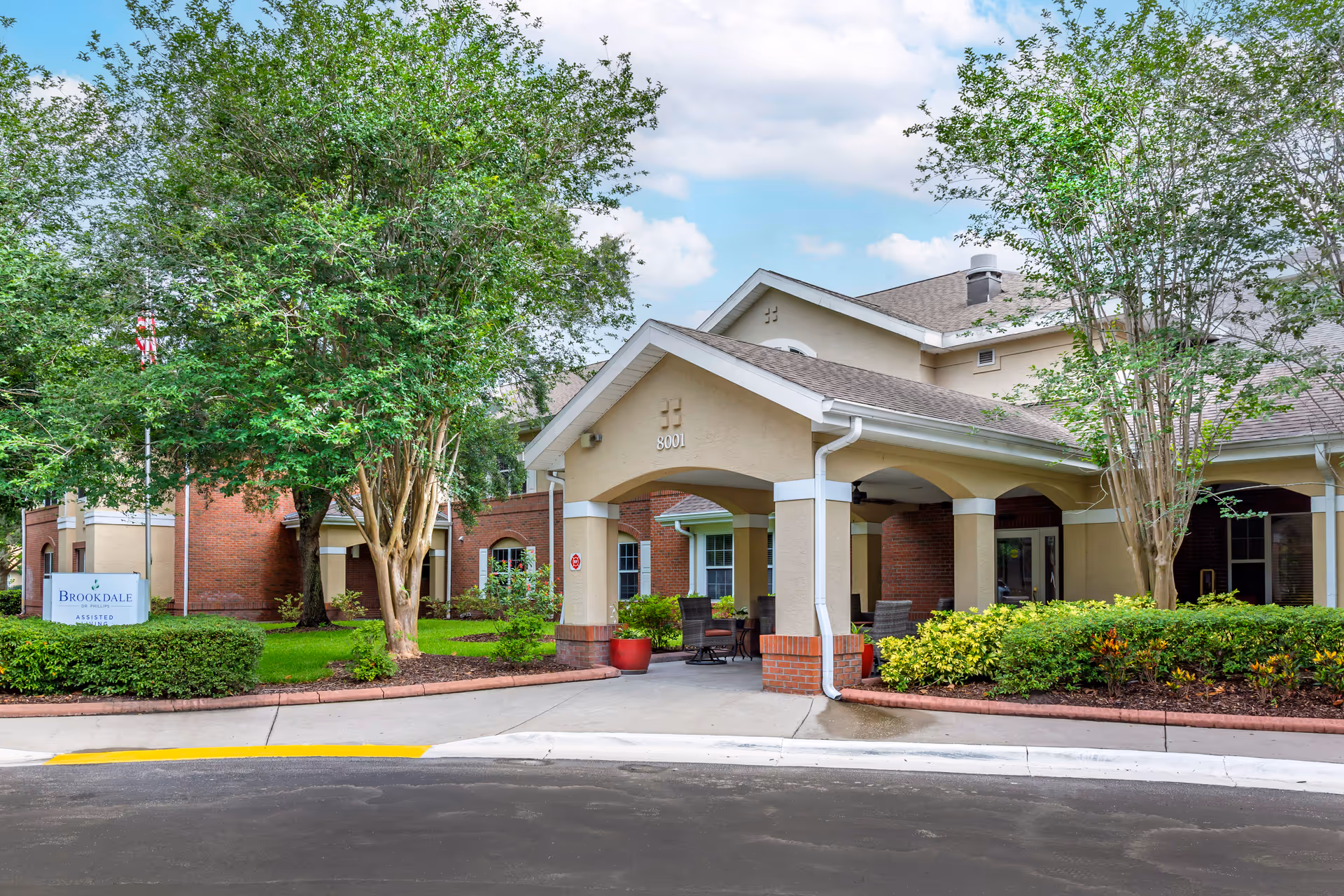 Brentwood Tower senior living facility entrance with a covered drop-off and landscaping