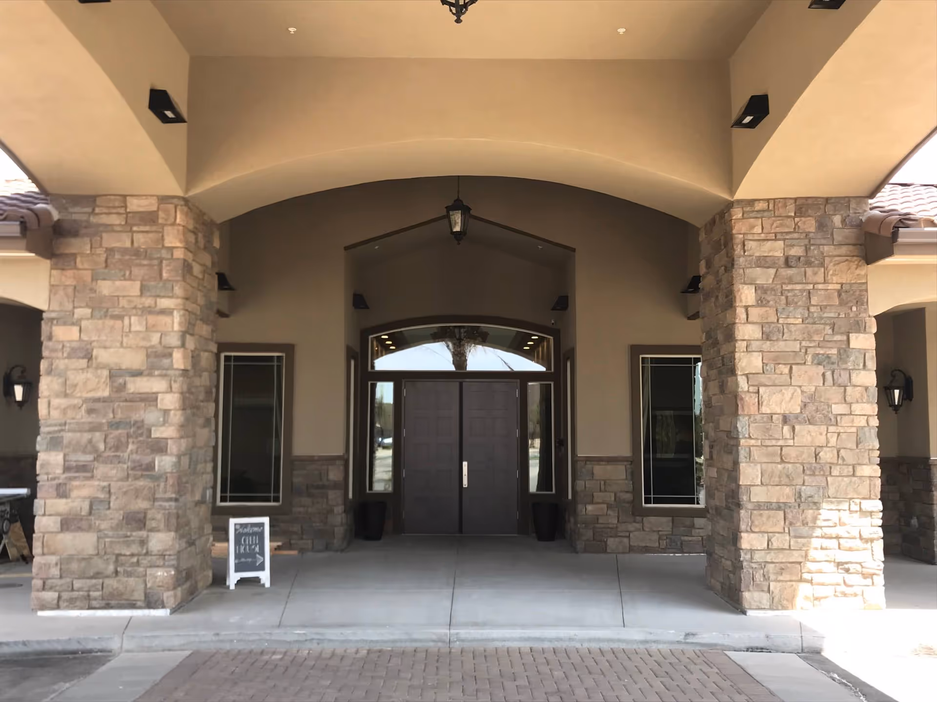 Parkland Memory Care entrance with stone columns, arched doorway, and double doors.