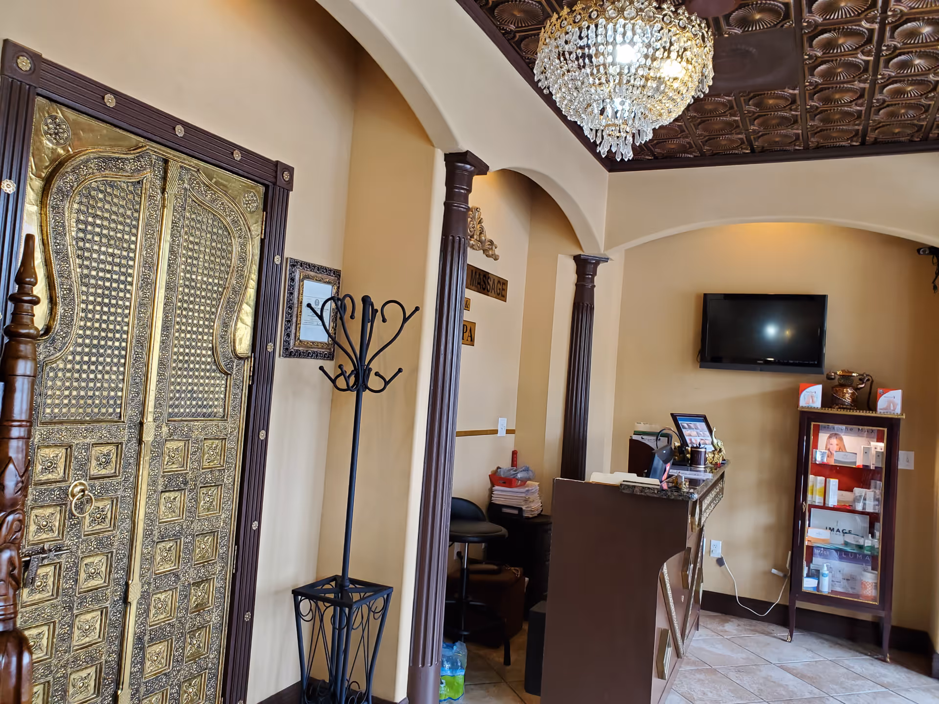 Ornate gold door beside a reception desk in a spa lobby.