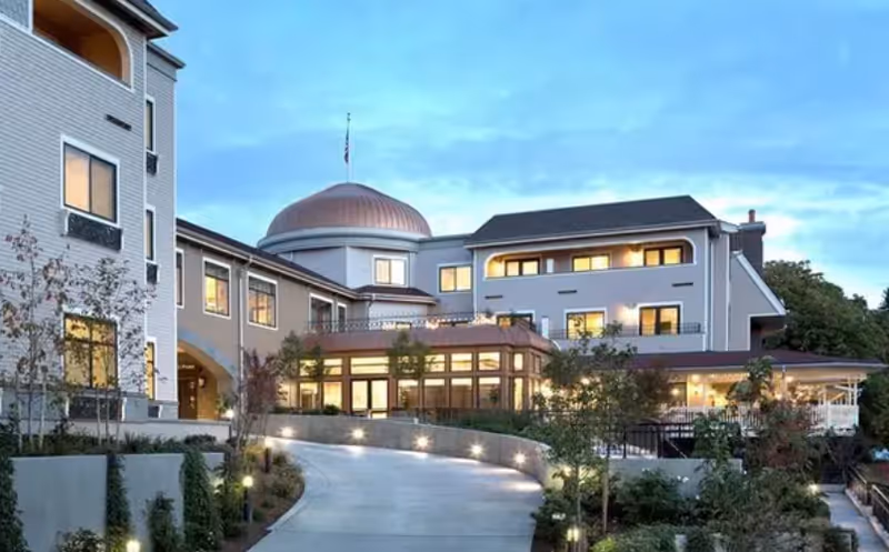 Exterior view of a modern senior living facility with a curved driveway.
