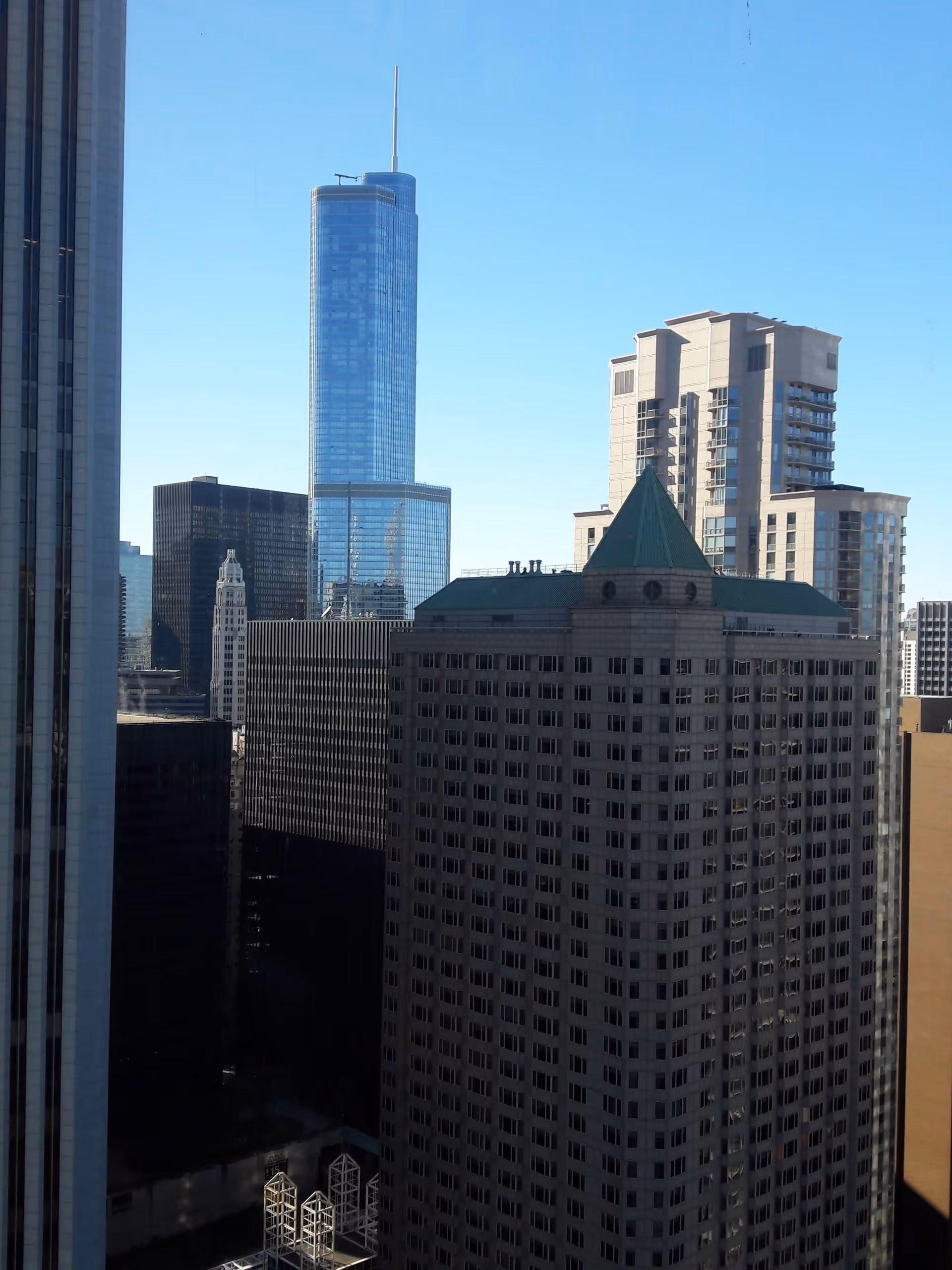City skyline featuring tall skyscrapers viewed from a high-rise window.