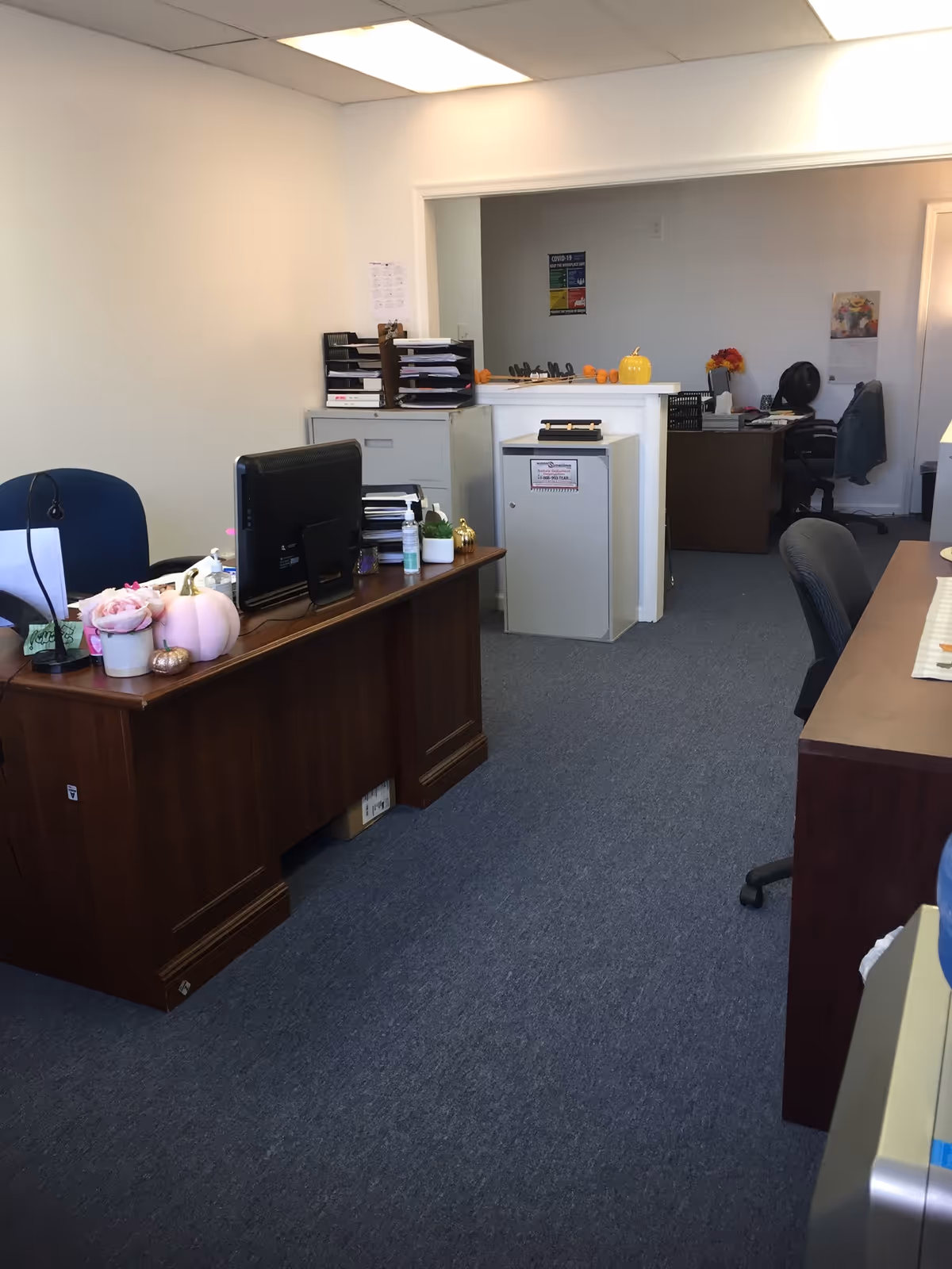 Office area with desks, computers, and filing cabinets in a senior care facility.