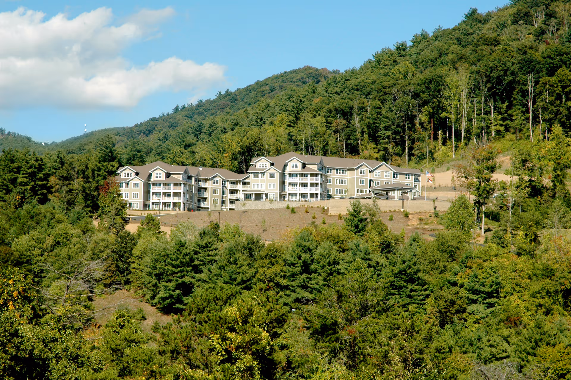 Exterior view of Bella Vista Gracious Retirement Living on a hillside among trees.