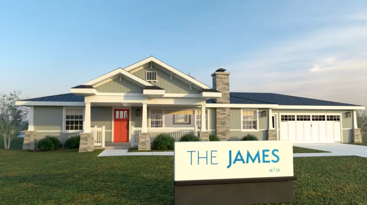 Modern single-story senior living facility exterior with a front entry and sign.