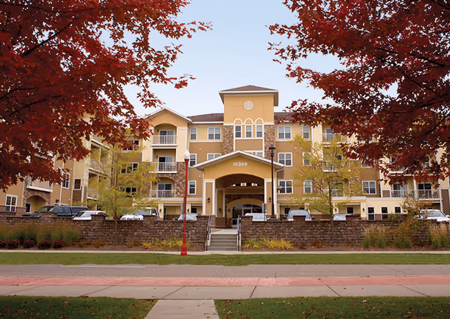 Exterior view of Ecumen Seasons at Apple Valley with autumn trees framing the entrance.