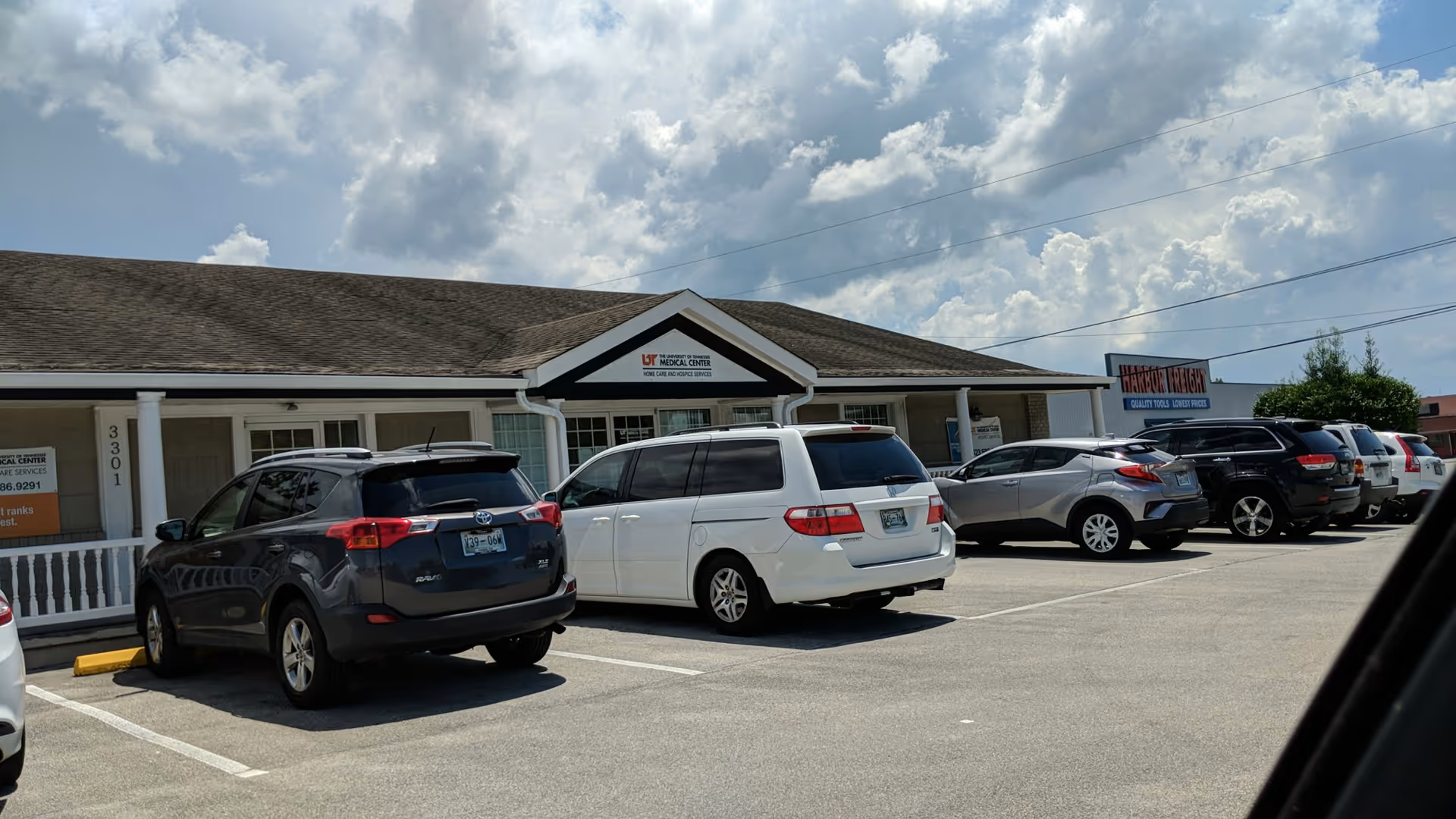 Front exterior of University of Tennessee Medical Center Hospice Services building with parked cars.
