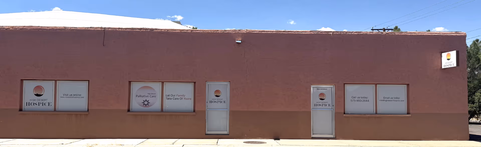 Exterior view of High Desert Hospice building with windows and signs.
