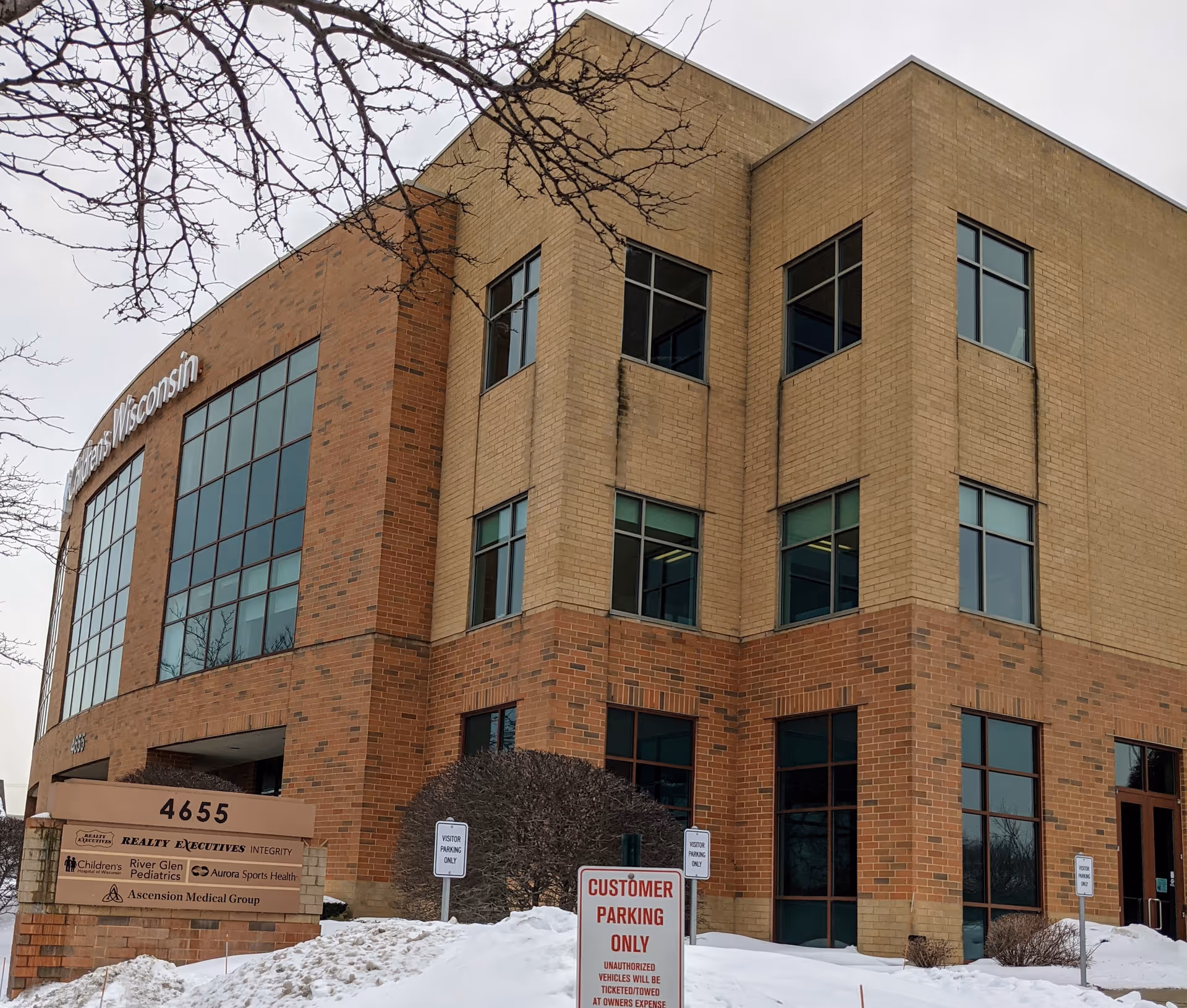 Exterior view of a brick, multi-story healthcare facility with large windows.