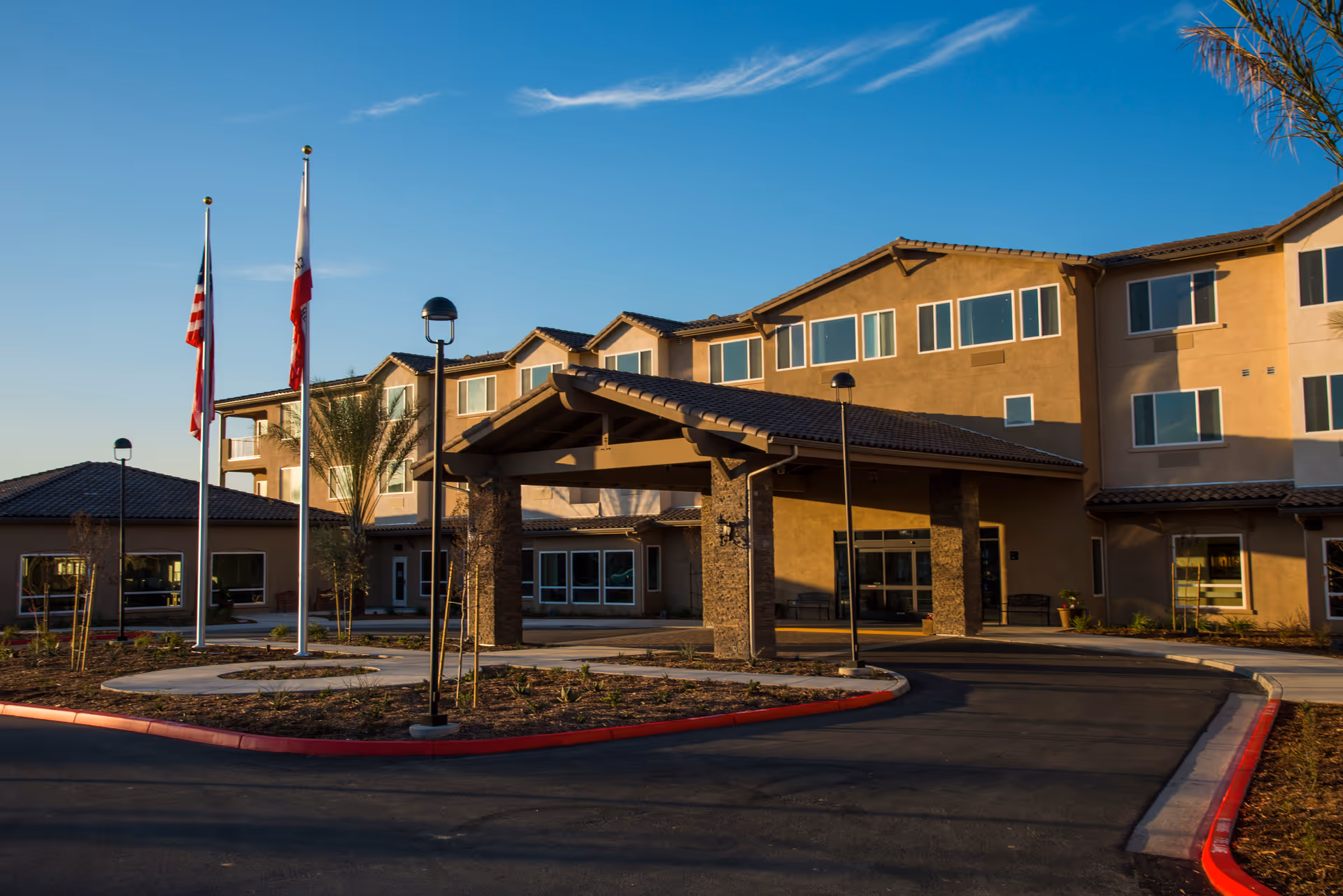 Front exterior of Renaissance Village Murrieta senior living facility with covered entrance.