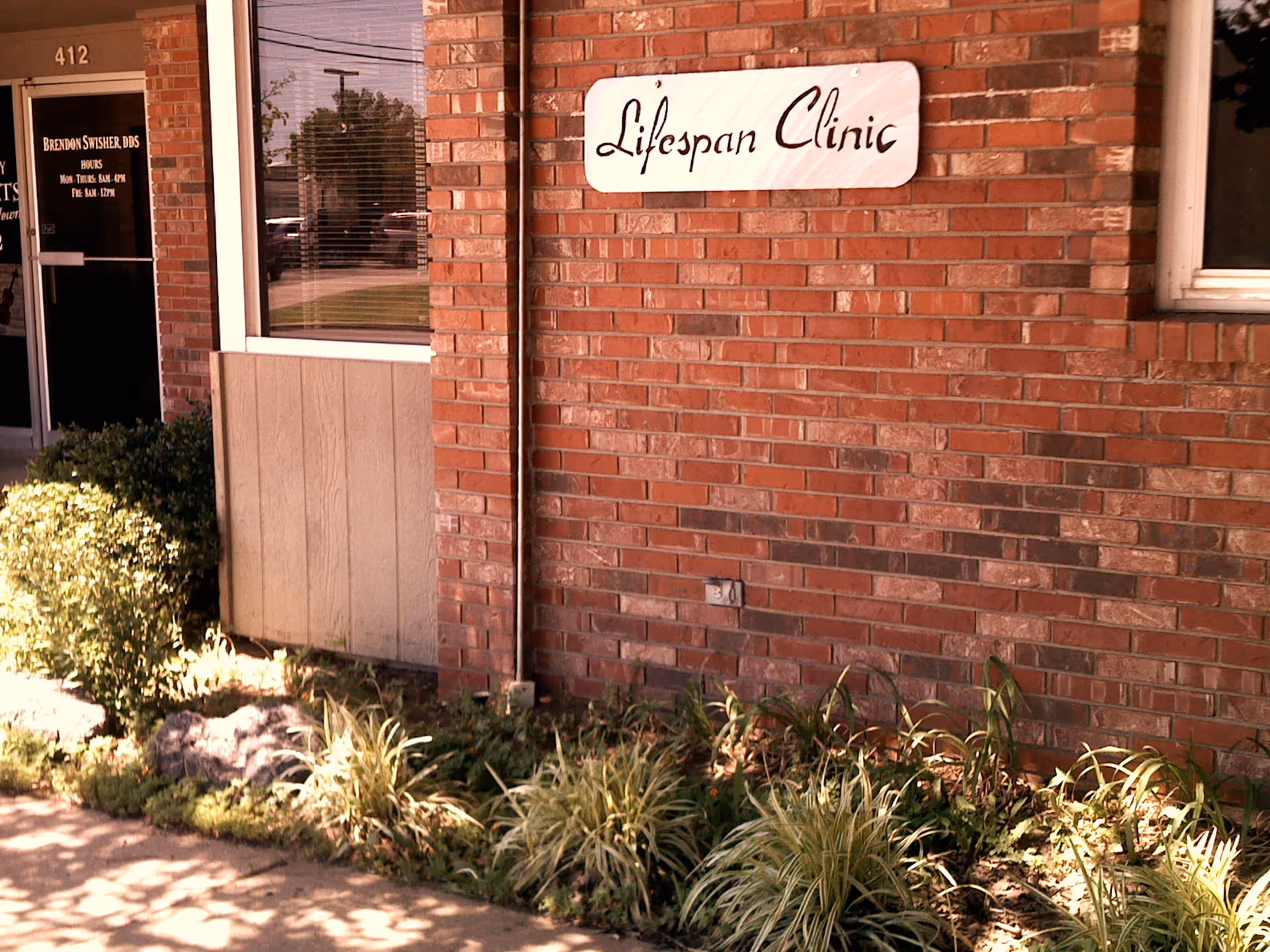 Brick building exterior with a Lifespan Clinic sign and landscaped foreground.