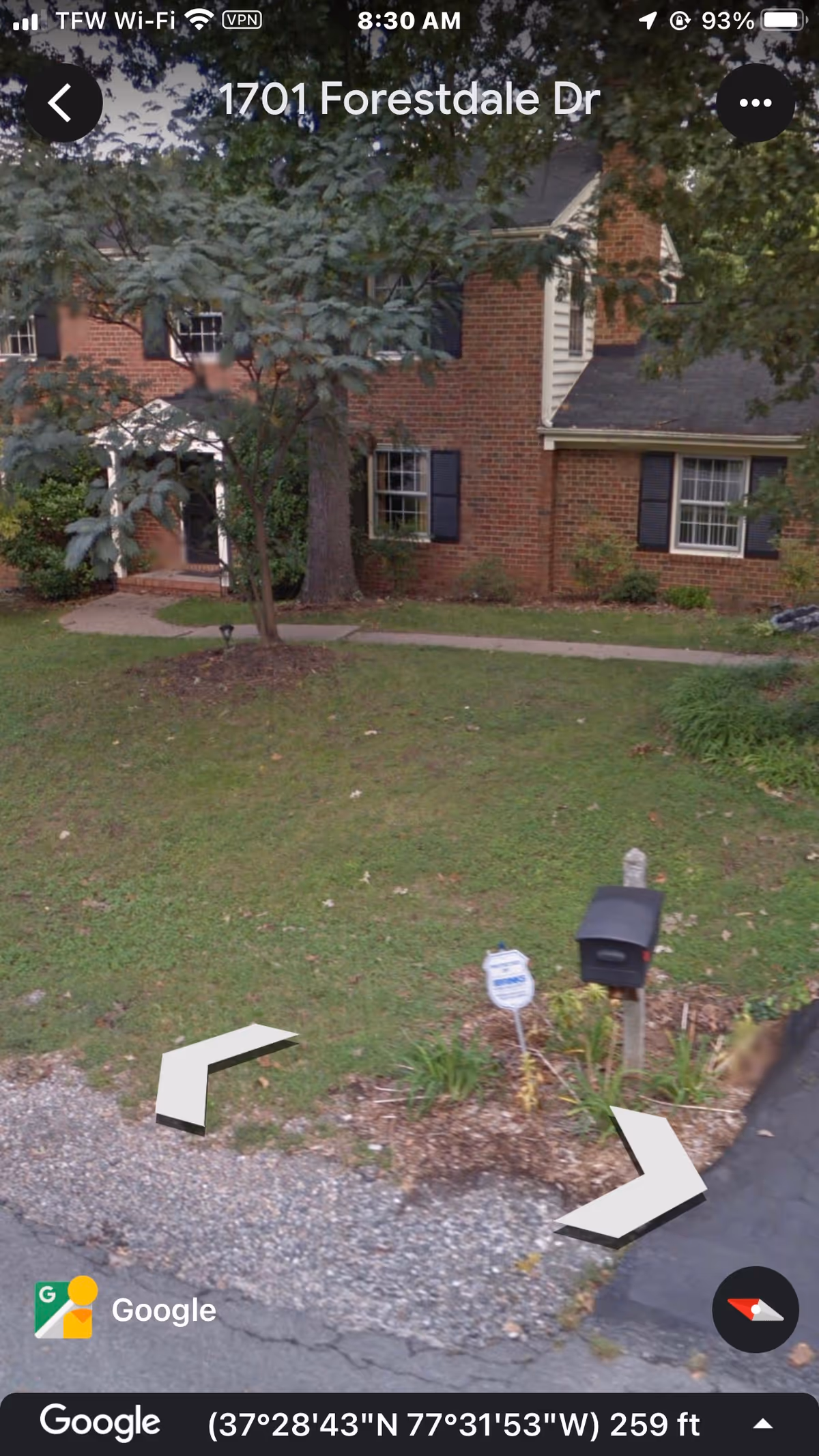 Exterior view of a brick senior living building with front walkway and mailbox.