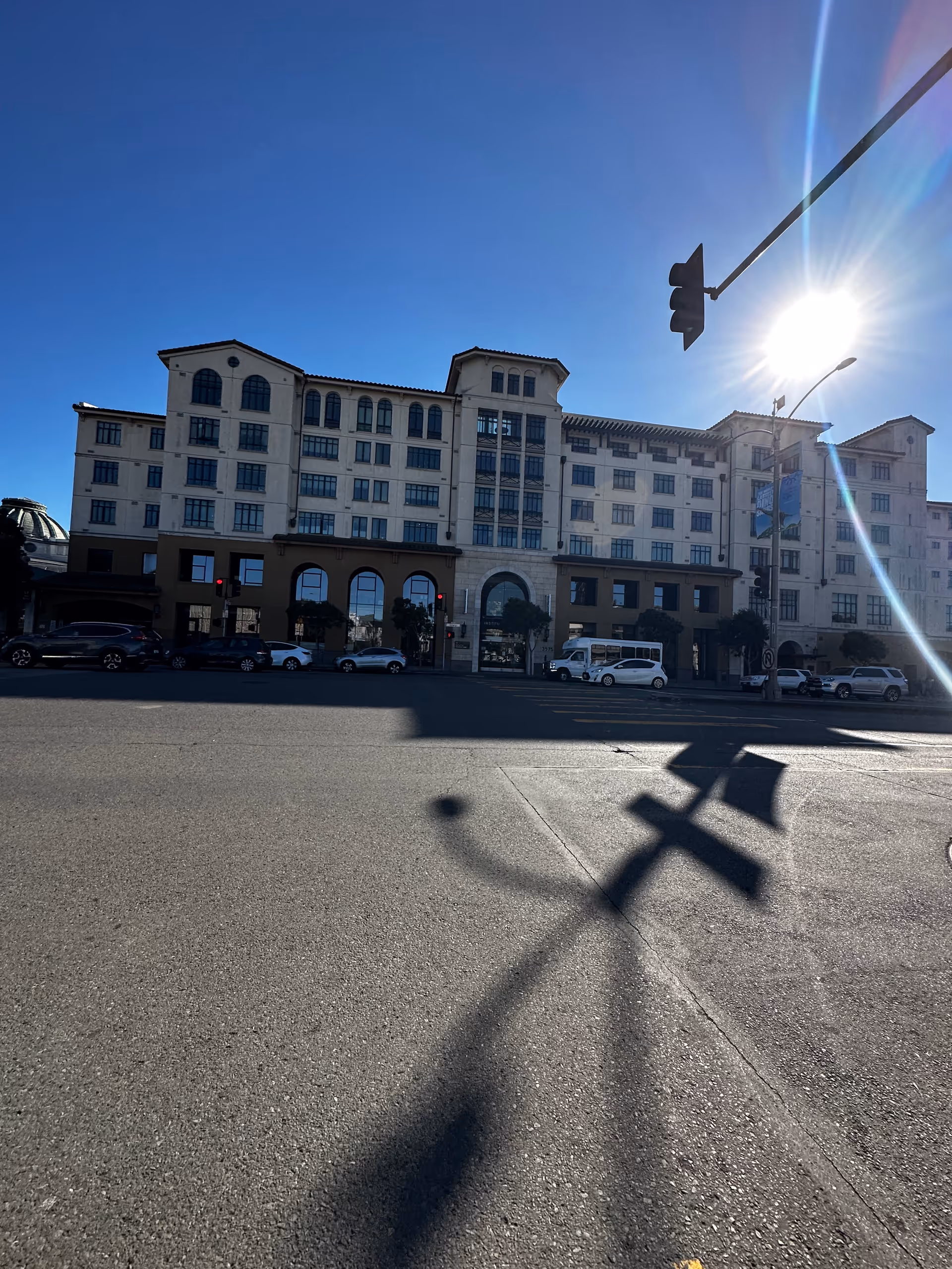 Front view of a multi-story senior living facility along a sunny city street.