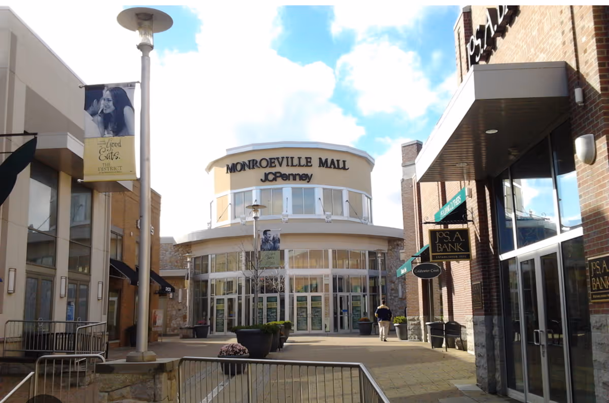 Exterior view of Monroeville Mall with JC Penney, storefronts, and pedestrians.