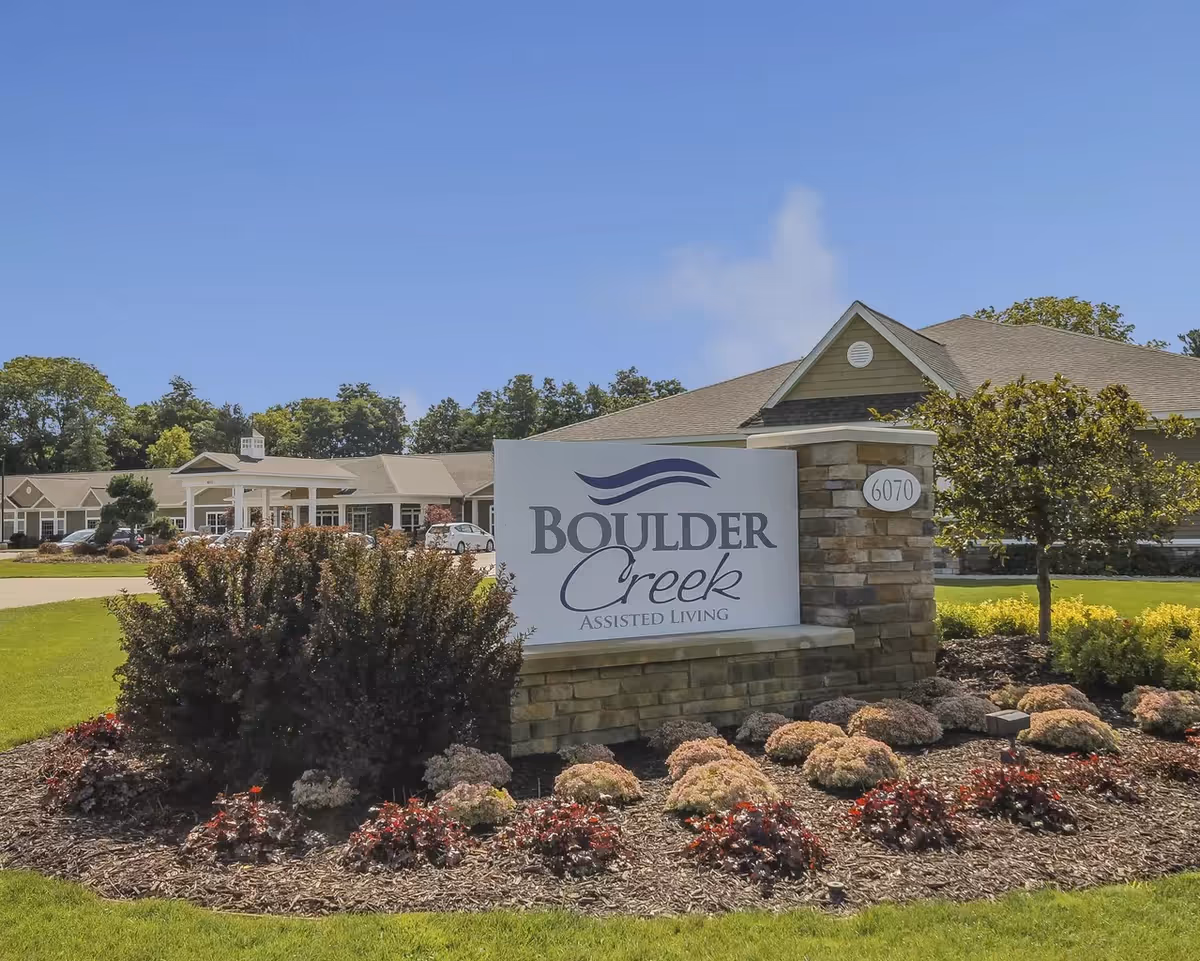 Exterior view of Boulder Creek Assisted Living with a landscaped entrance sign