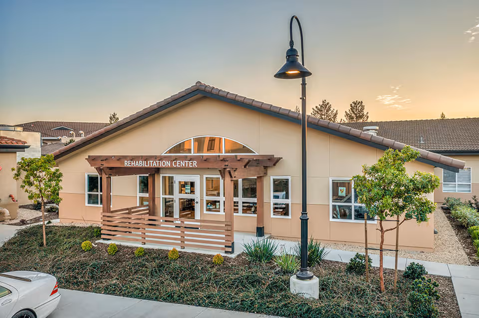 Exterior view of The Meadows of Napa Valley rehabilitation center entrance with wooden porch.