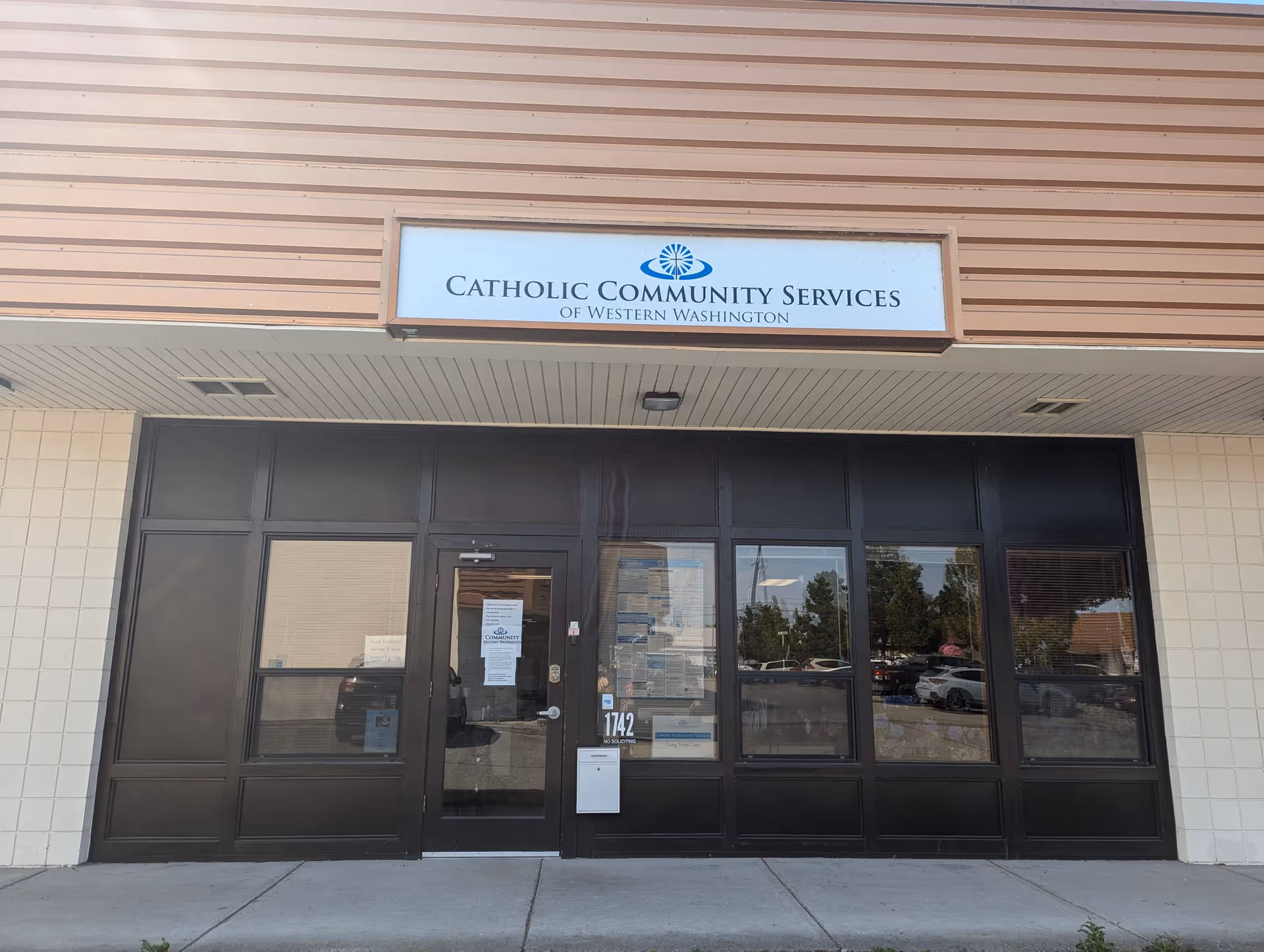Front entrance of Catholic Community Services of Western Washington building with glass doors.