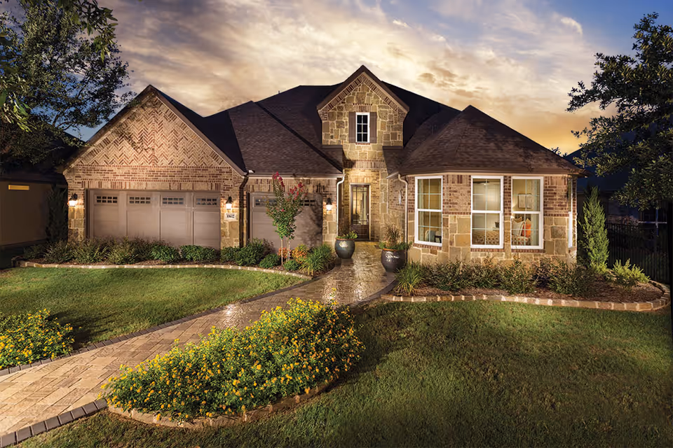 Stone and brick senior living facility exterior with a driveway and landscaped front entrance.