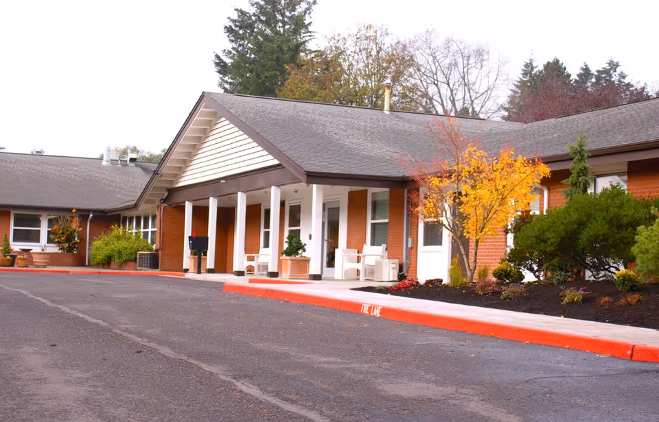 Exterior view of Village Health Care's brick building with a covered front entrance and landscaping.