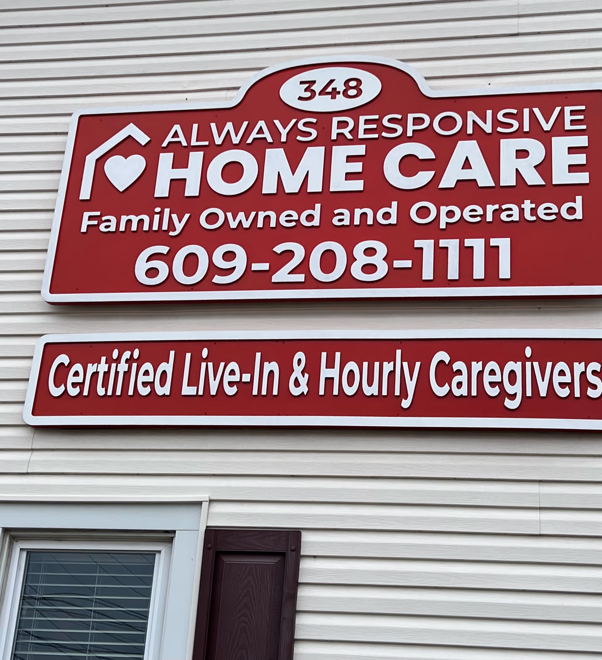Red sign on beige building displays Always Responsive Home Care and phone number.