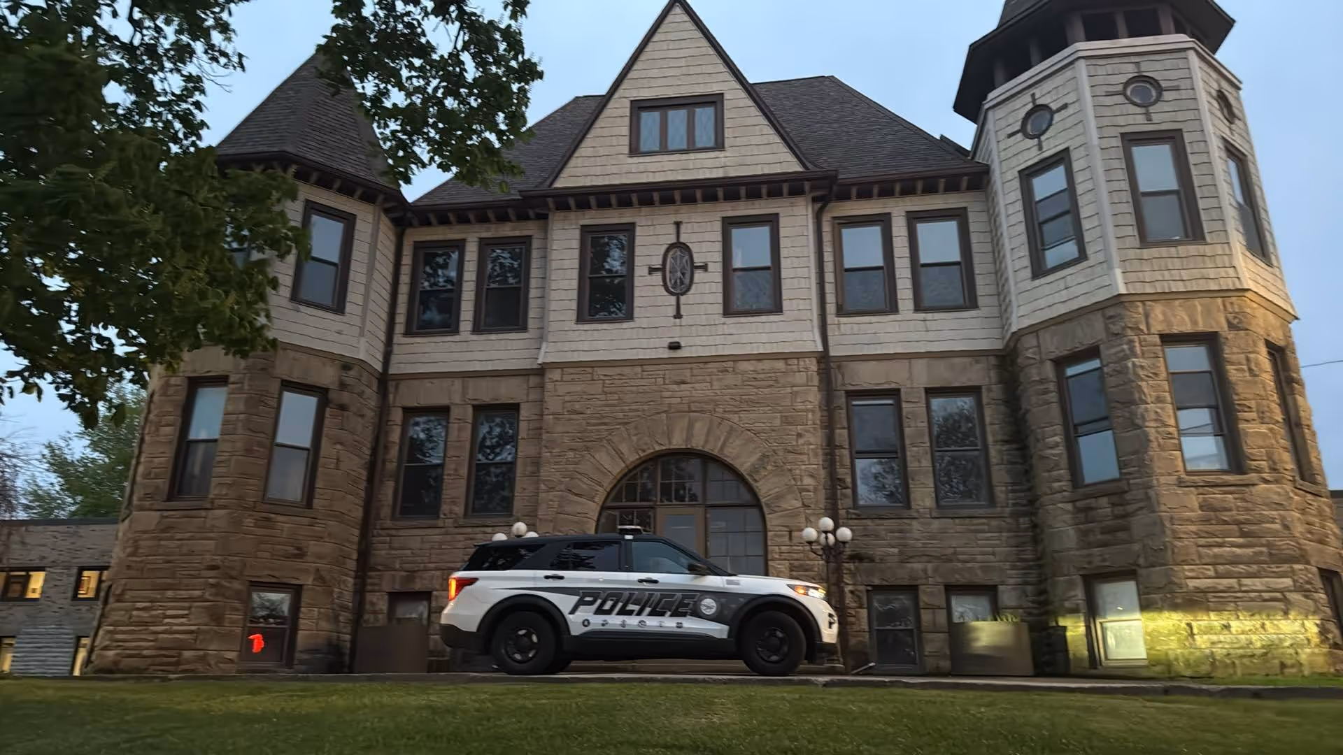 Front view of the Ohio Veterans Home building with a police SUV parked outside.
