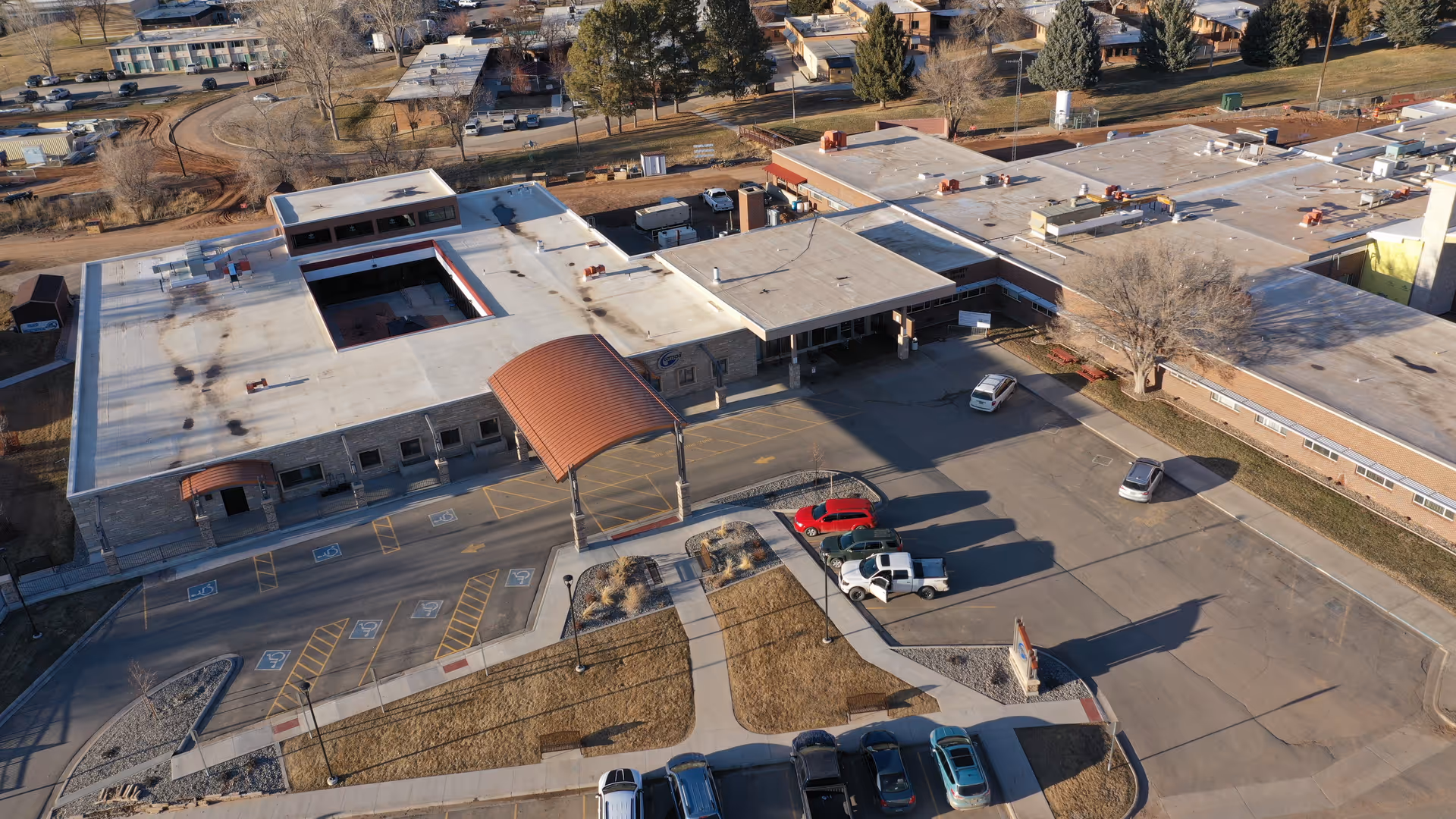 Aerial view of a senior living facility with a front entrance canopy and parking.