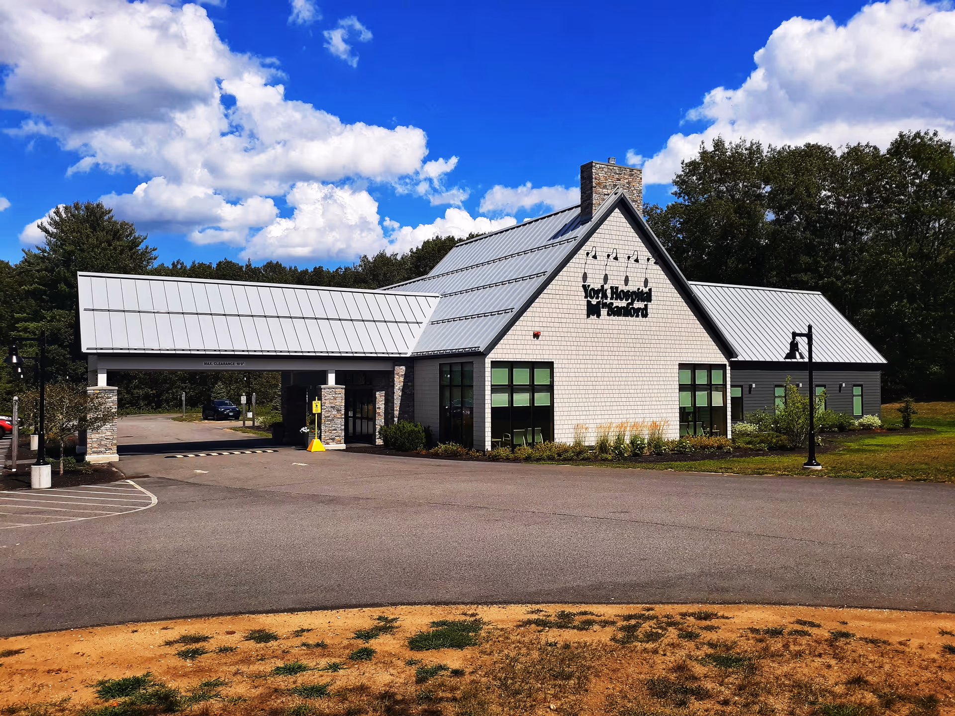 Front view of York Hospital in Sanford, a light-brick building with a metal roof and driveway.