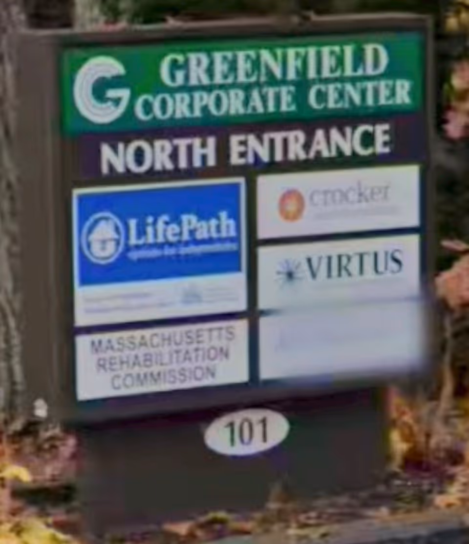 A signboard outside a building displays Greenfield Corporate Center logos and North Entrance.