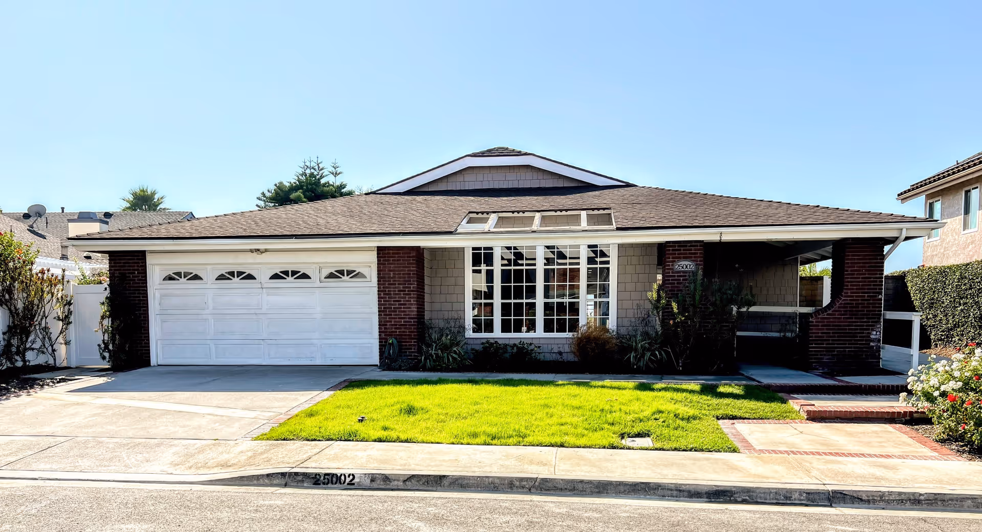 Front view of a single-story building with a two-car garage and manicured lawn.