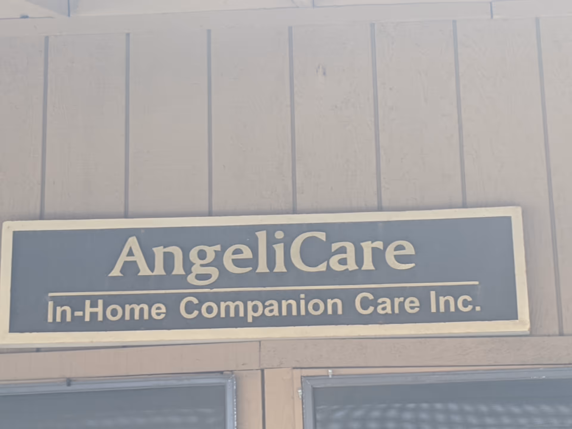 Exterior sign on a building reads Angelicare In-Home Companion Care Inc.
