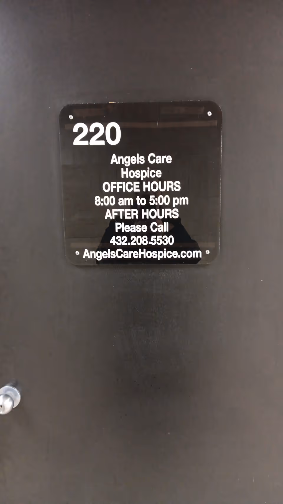 Door plaque showing 220 and Angels Care Hospice office hours and phone number.