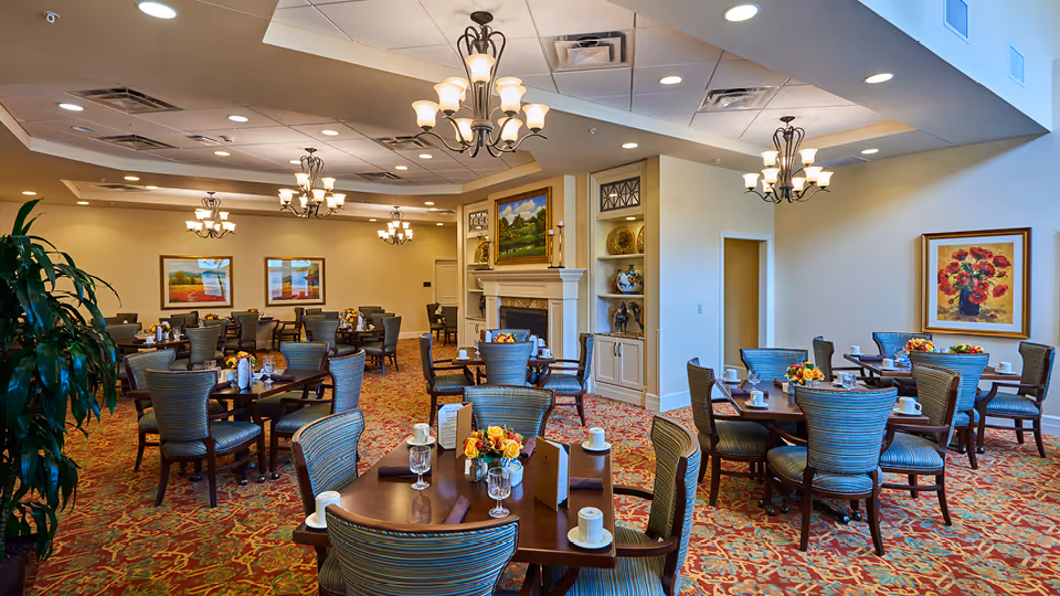 Spacious dining room at Park Street Home with several tables, chairs, and chandeliers.