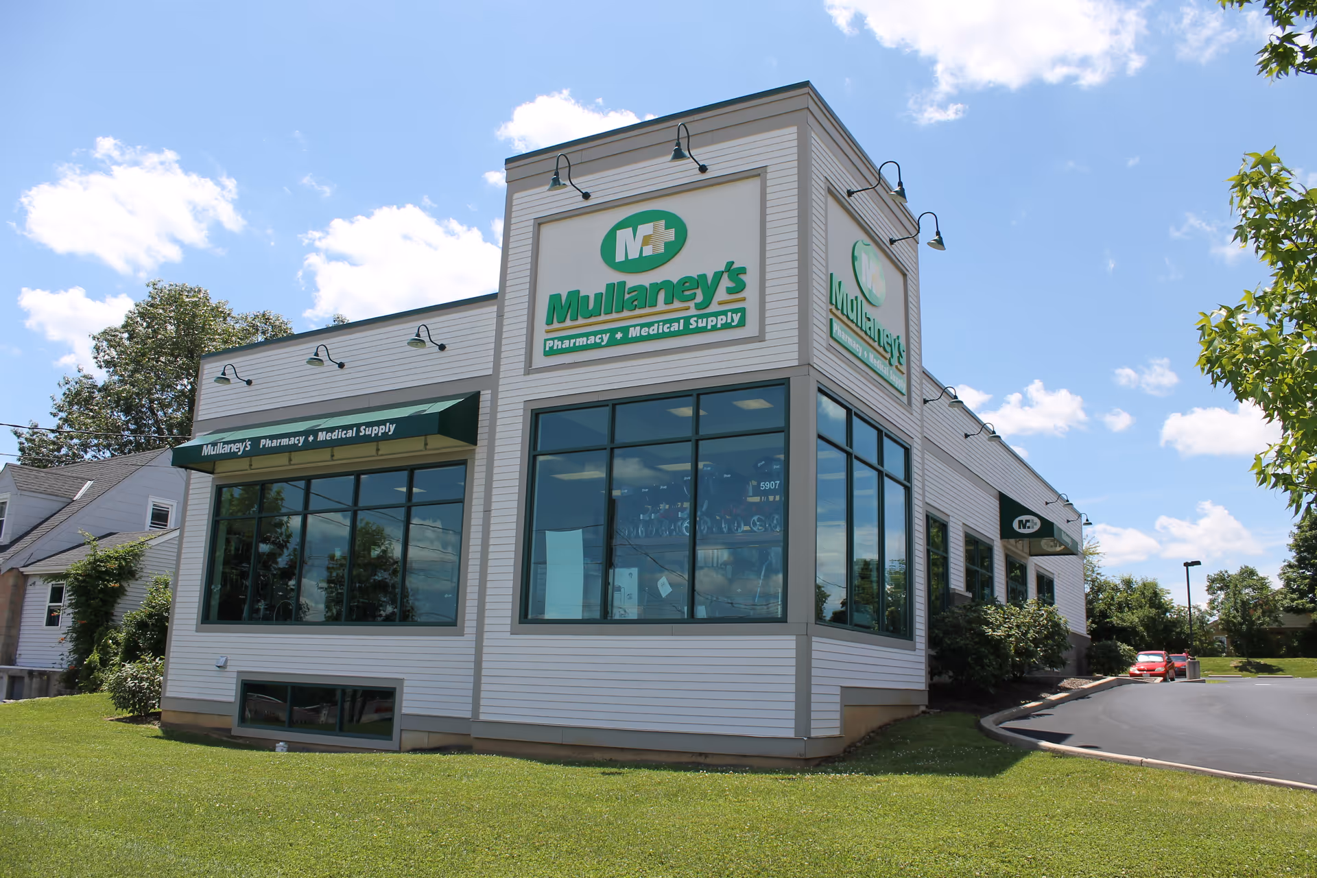 White storefront building with green Mullaney's Pharmacy and Medical Supply signage.