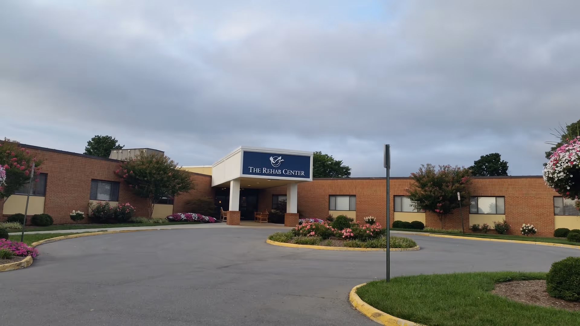 Brick exterior of a senior living facility with a covered entrance and manicured landscaping.
