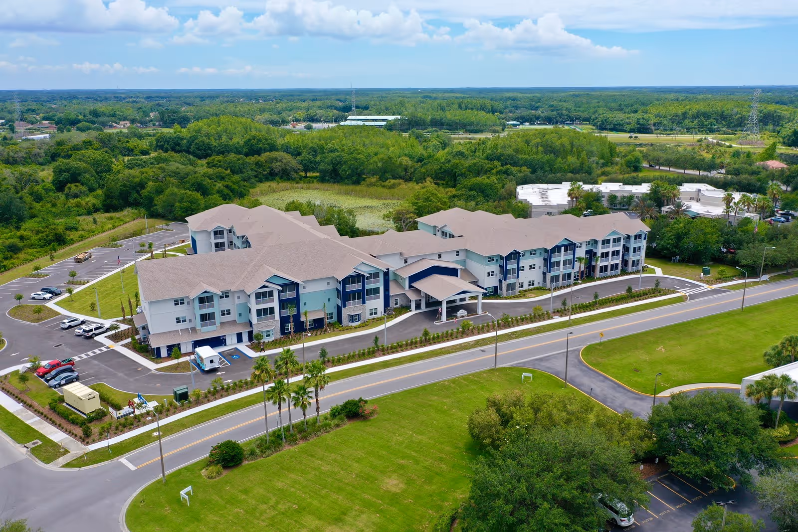 Aerial view of Sunflower Springs at Trinity exterior with entrance, parking, and greenery.