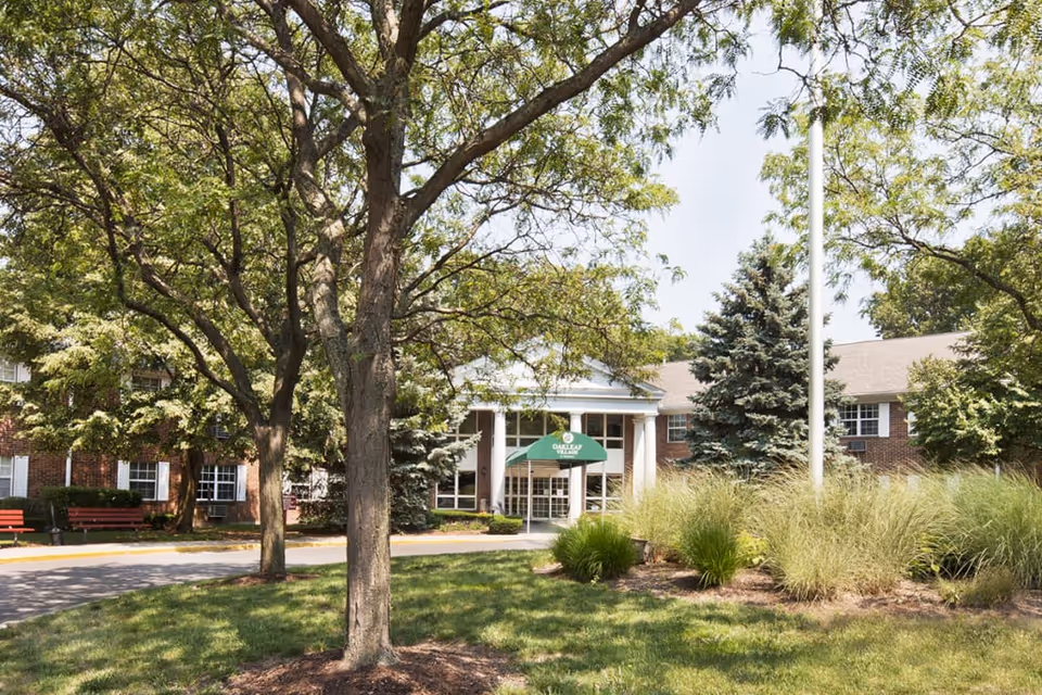 Exterior view of Oakleaf Village of Toledo Sylvania entrance framed by trees.