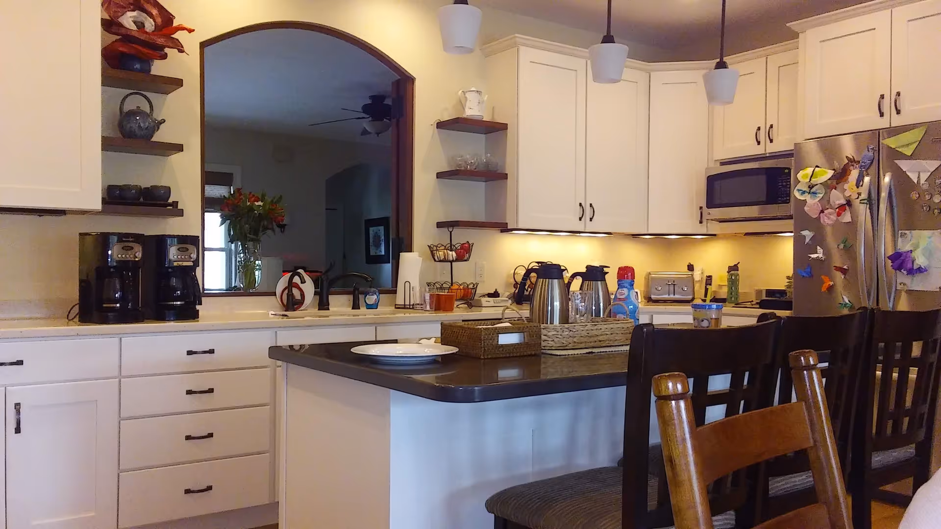 Bright white kitchen with island, appliances, and stools in a senior living unit.