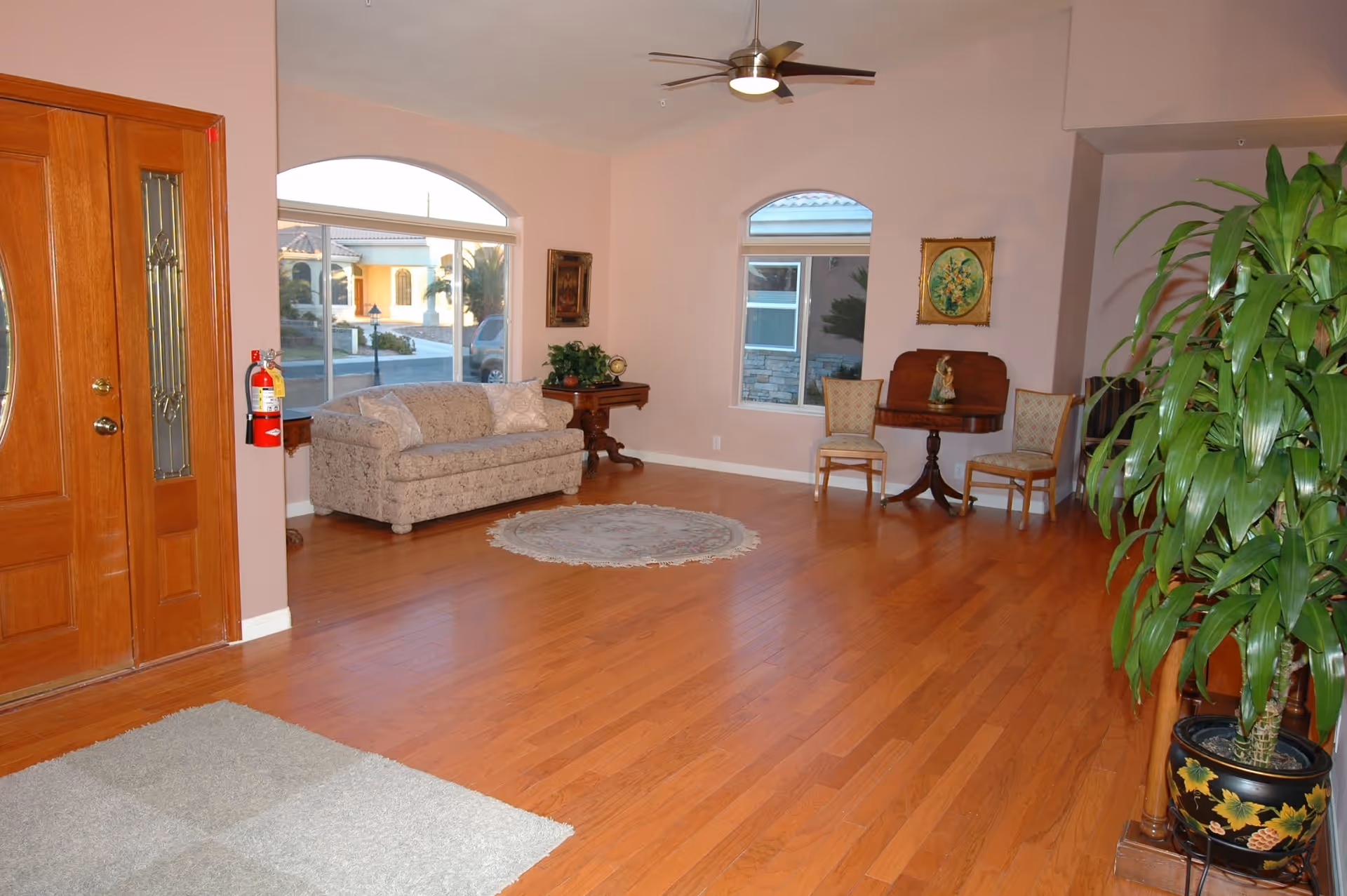 Spacious interior lounge with sofa, chairs, rug, and large windows in a senior residence.