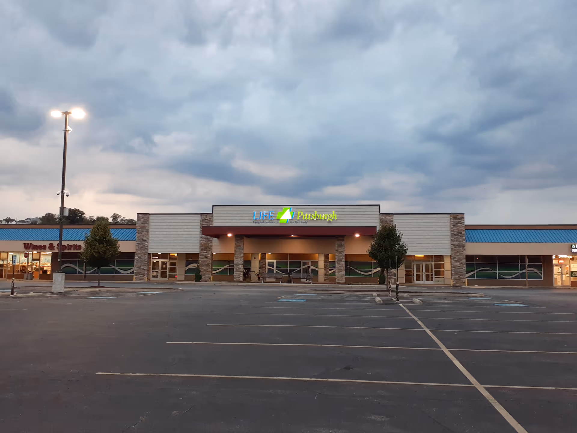 Front exterior of LIFE Pittsburgh building in a strip mall with a parking lot.