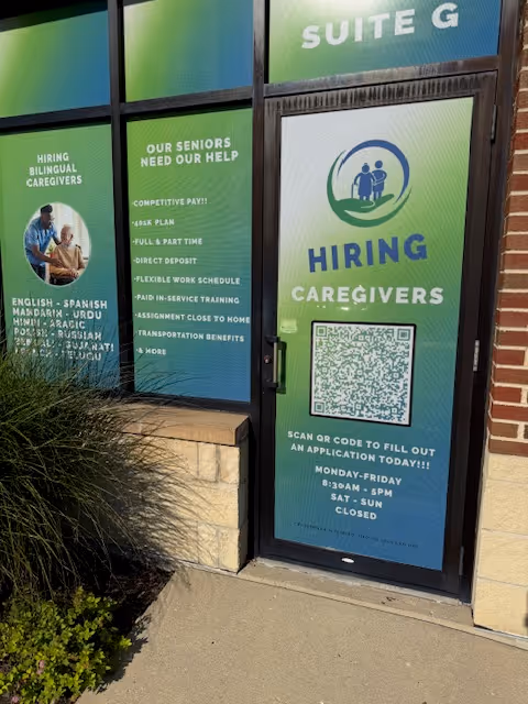 Exterior storefront window advertising caregiver hiring with QR code and job openings.