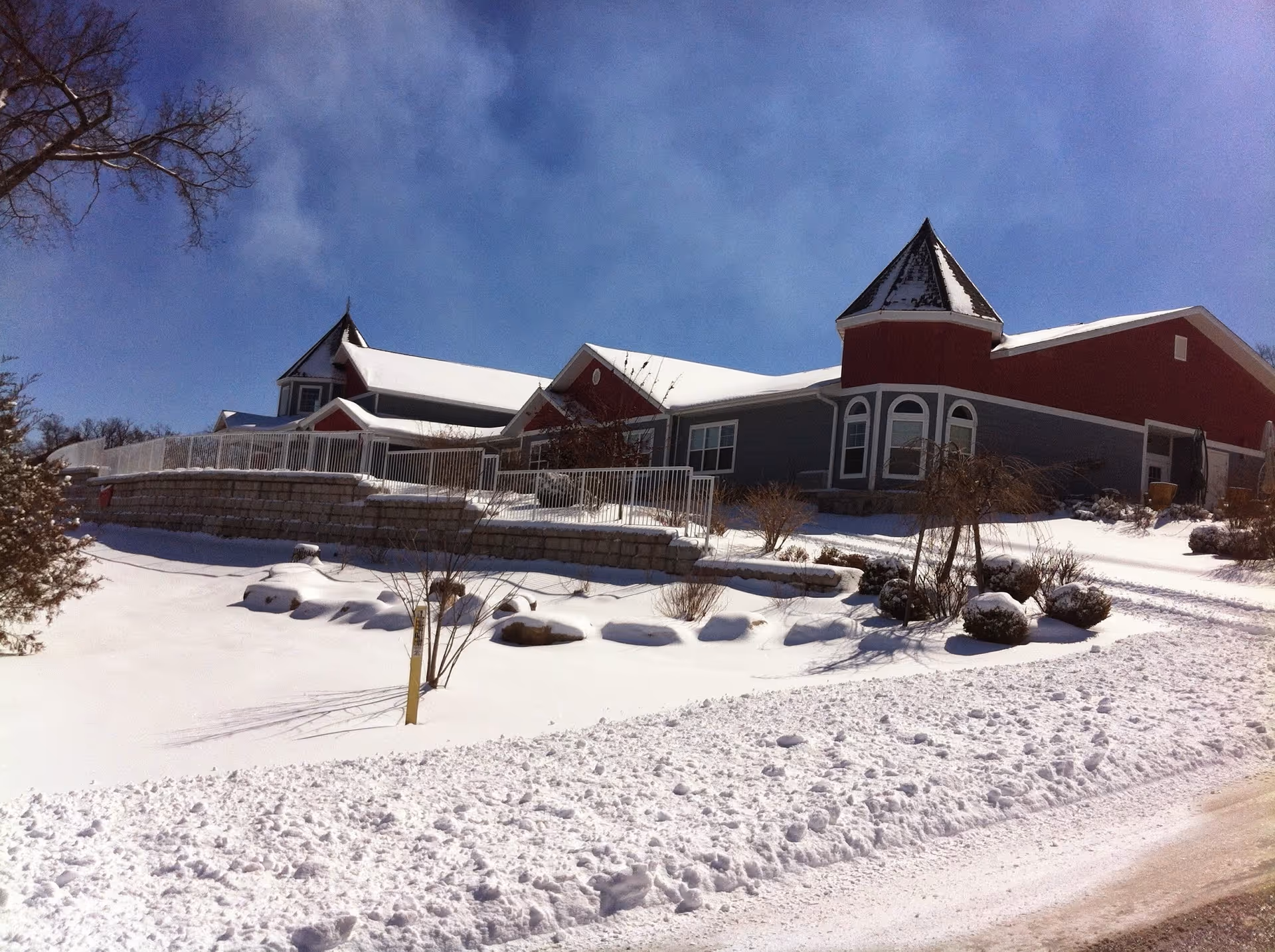 Snow-covered Rose House exterior with turreted roof and red-gray siding.