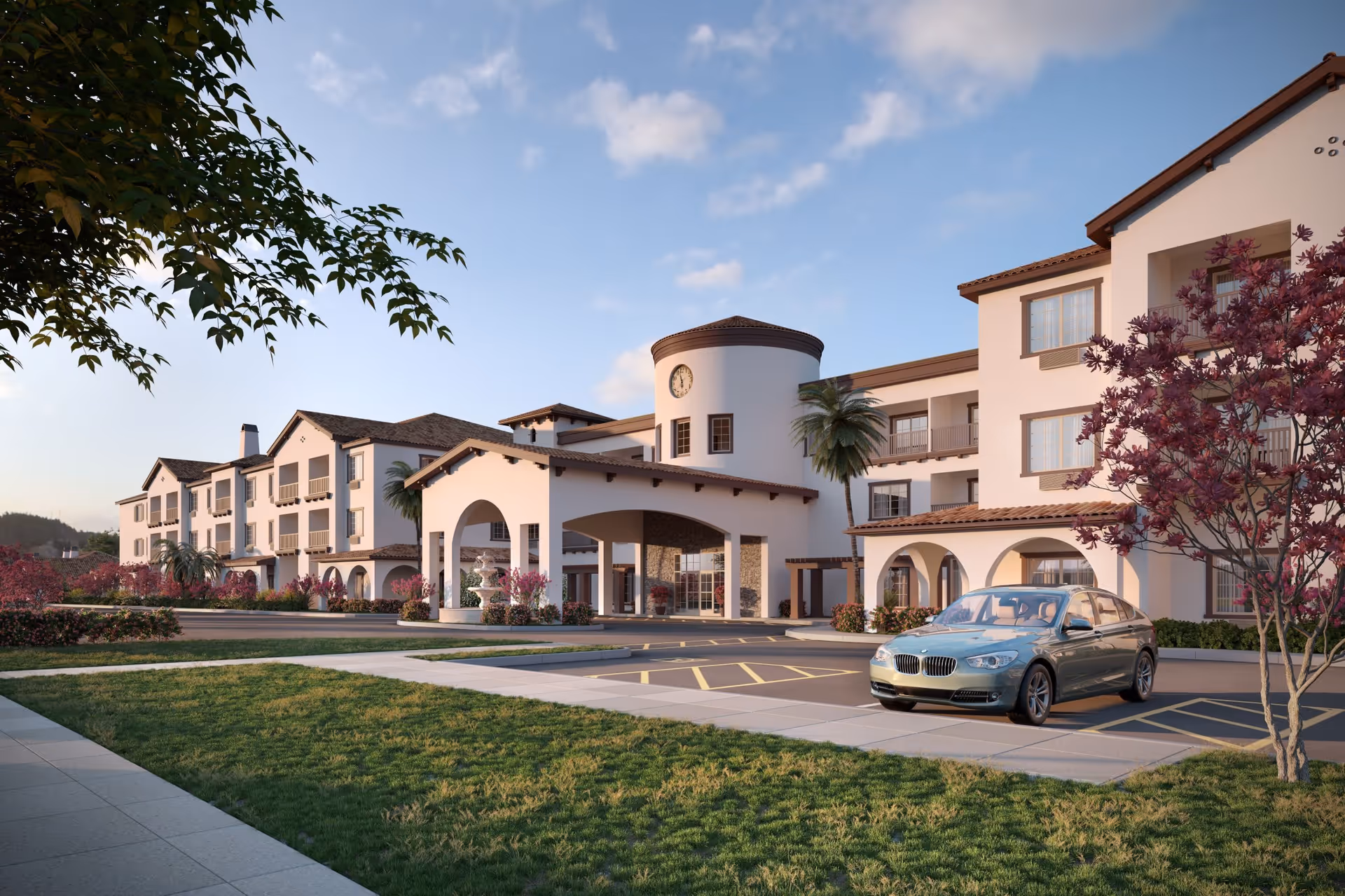 Exterior view of a large, multi-story senior living facility with Mediterranean-style architecture, featuring white walls, arched entryways, a clock tower, palm trees, and landscaped grounds with a parked car in front.