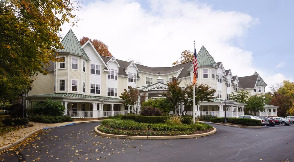 Sunrise of Haverford senior living building exterior with circular drive and flagpole.