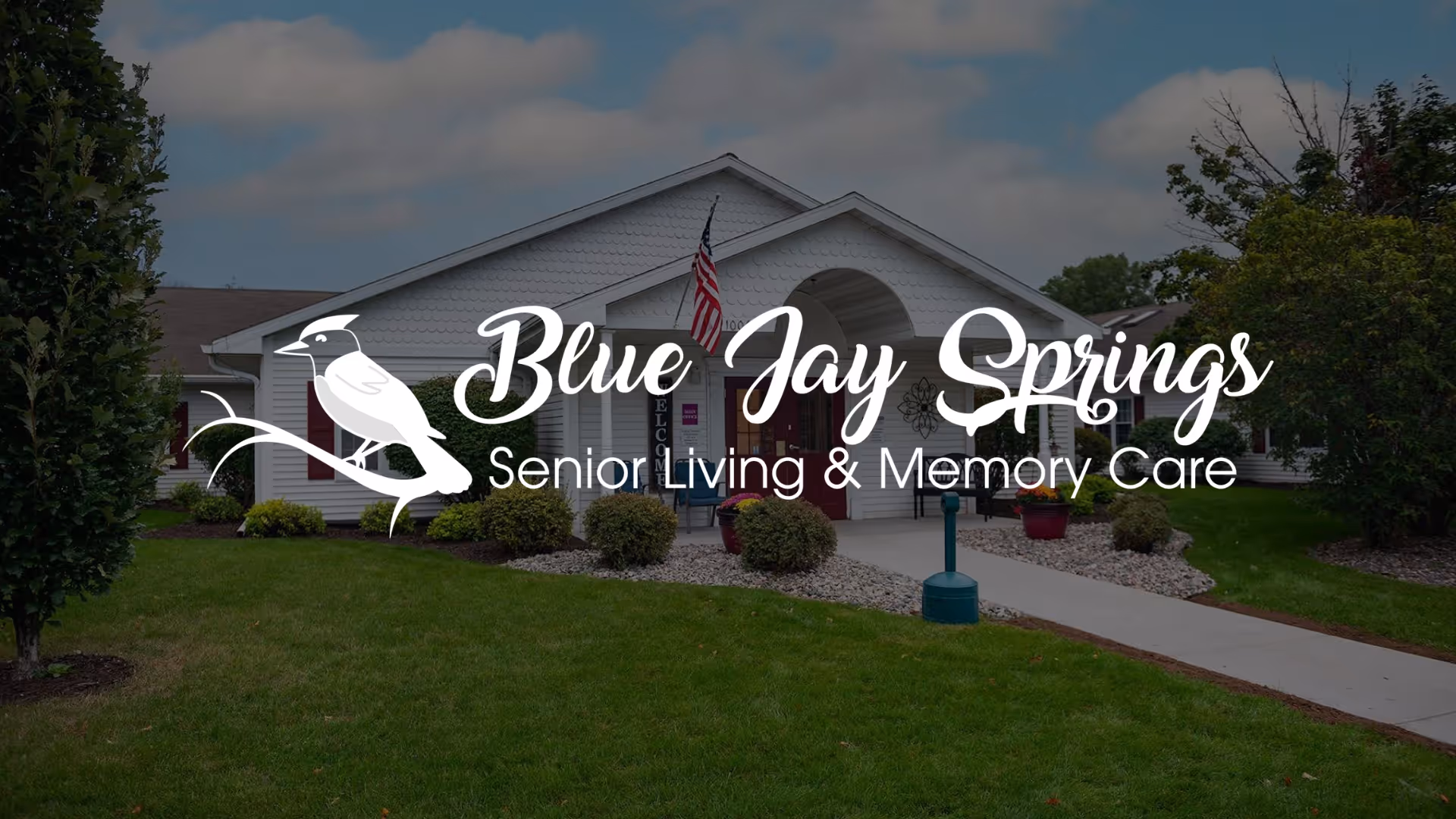 Exterior view of Blue Jay Springs Senior Living building with lawn and entrance.