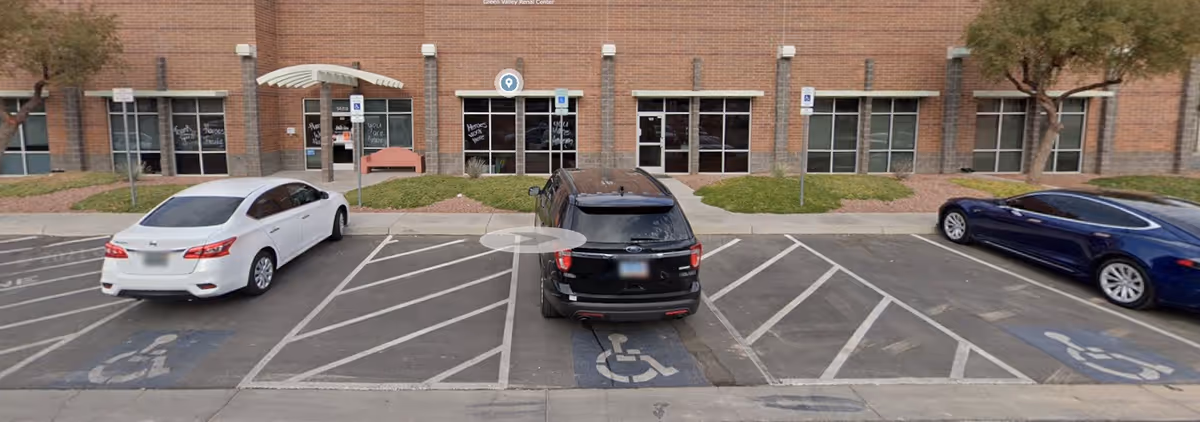 Exterior view of Senior Resource Nevada facility with brick facade and parked cars.